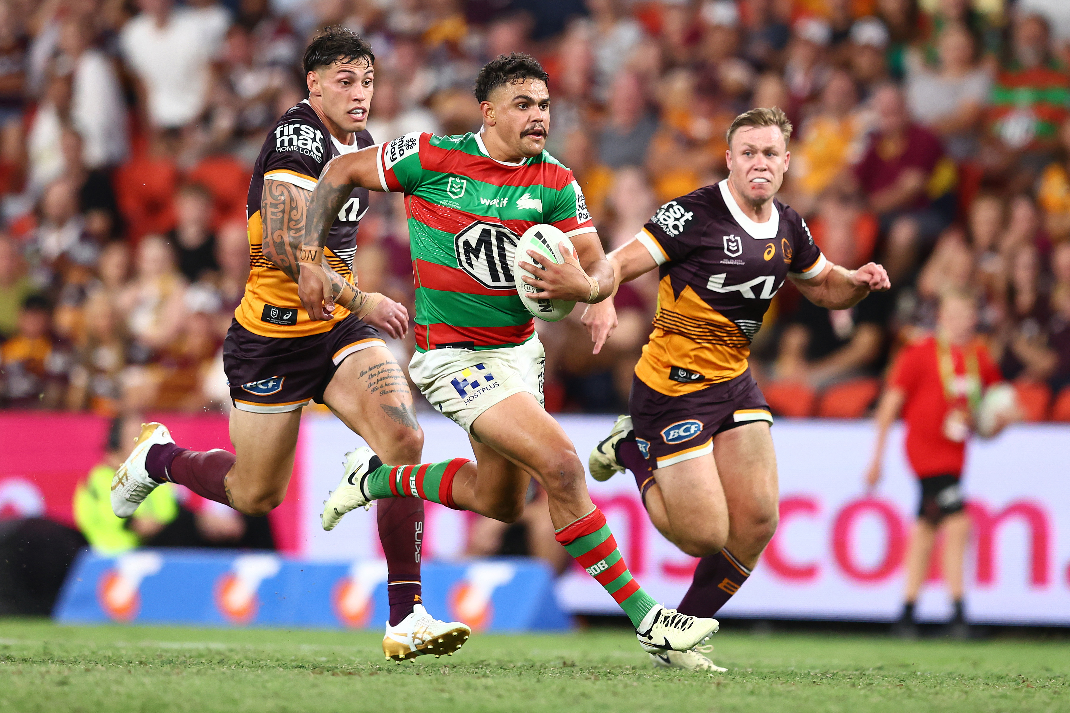 Latrell Mitchell of the Rabbitohs makes a break against the Broncos.