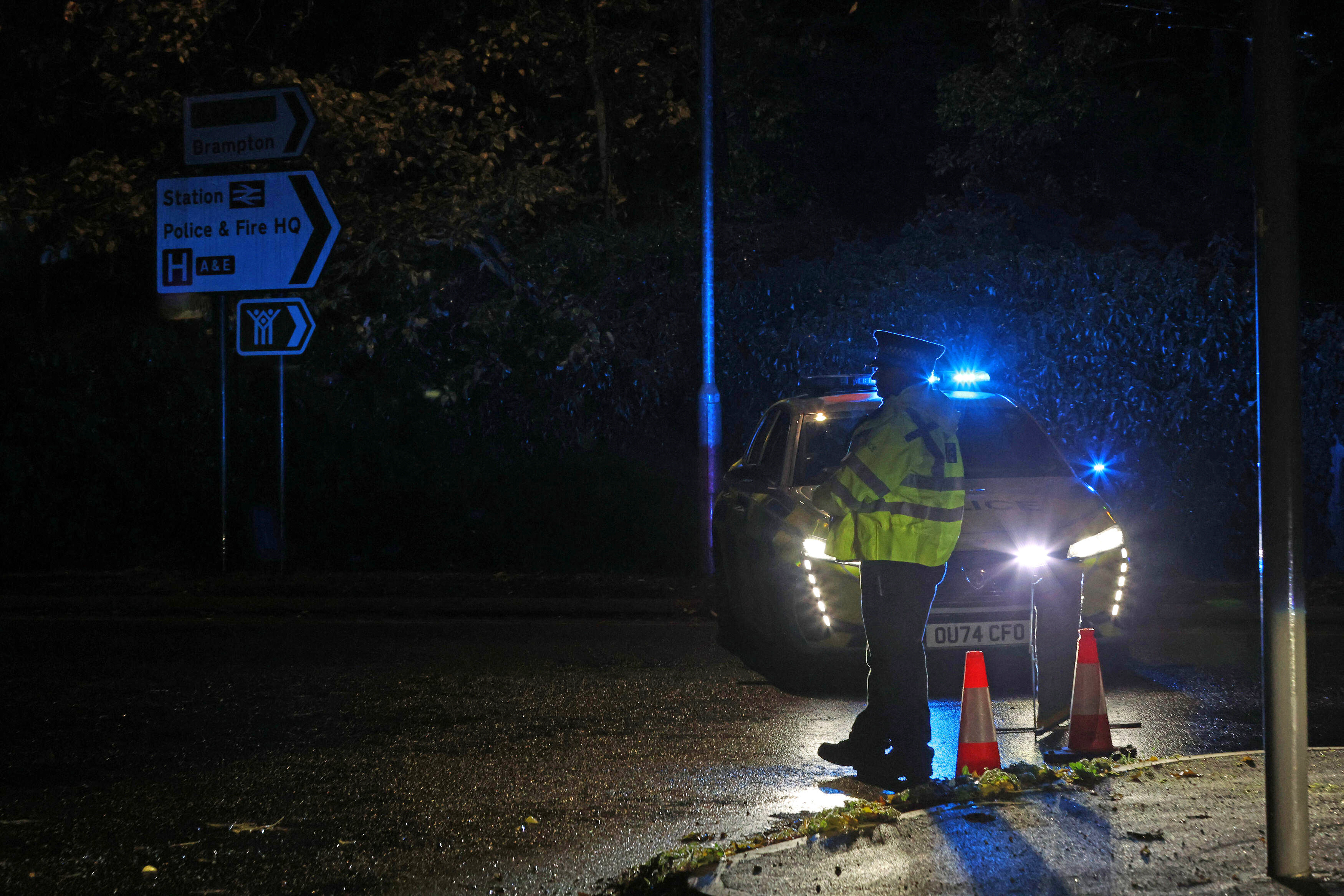 Police stand guard near the Huntingdon, England, train station in Cambridgeshire, after people were stabbed on a train, Saturday, Nov. 1, 2025. (Chris Radburn/PA via AP)