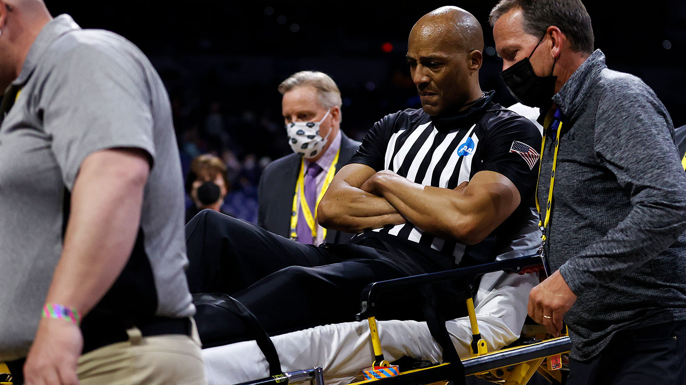 Referee Bert Smith is helped from the court after collapsing during the first quarter of the NCAA Elite Eight match between USC and Gonzaga in Indiana.
