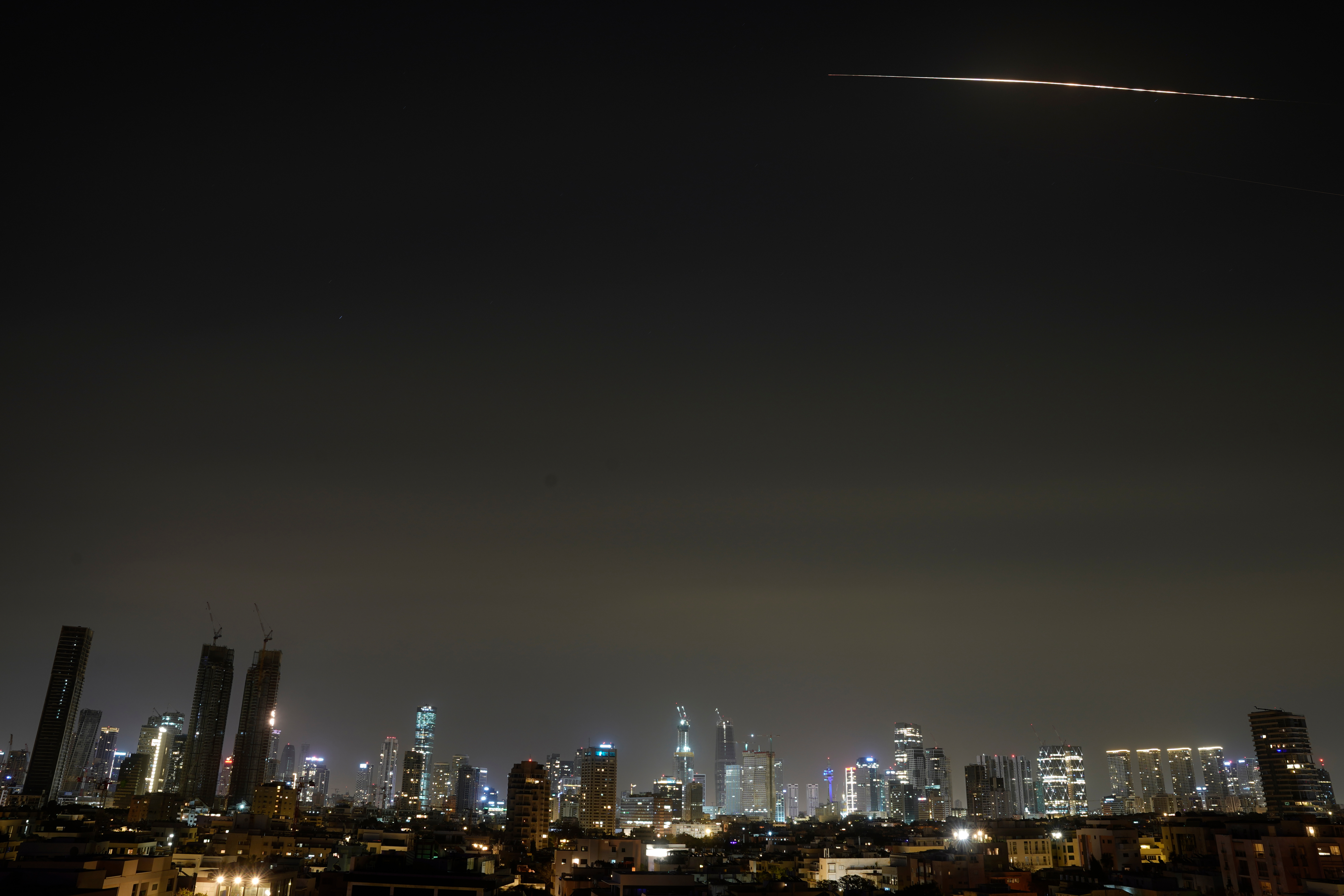 The remains of an Iranian missile cross the sky over Tel Aviv 