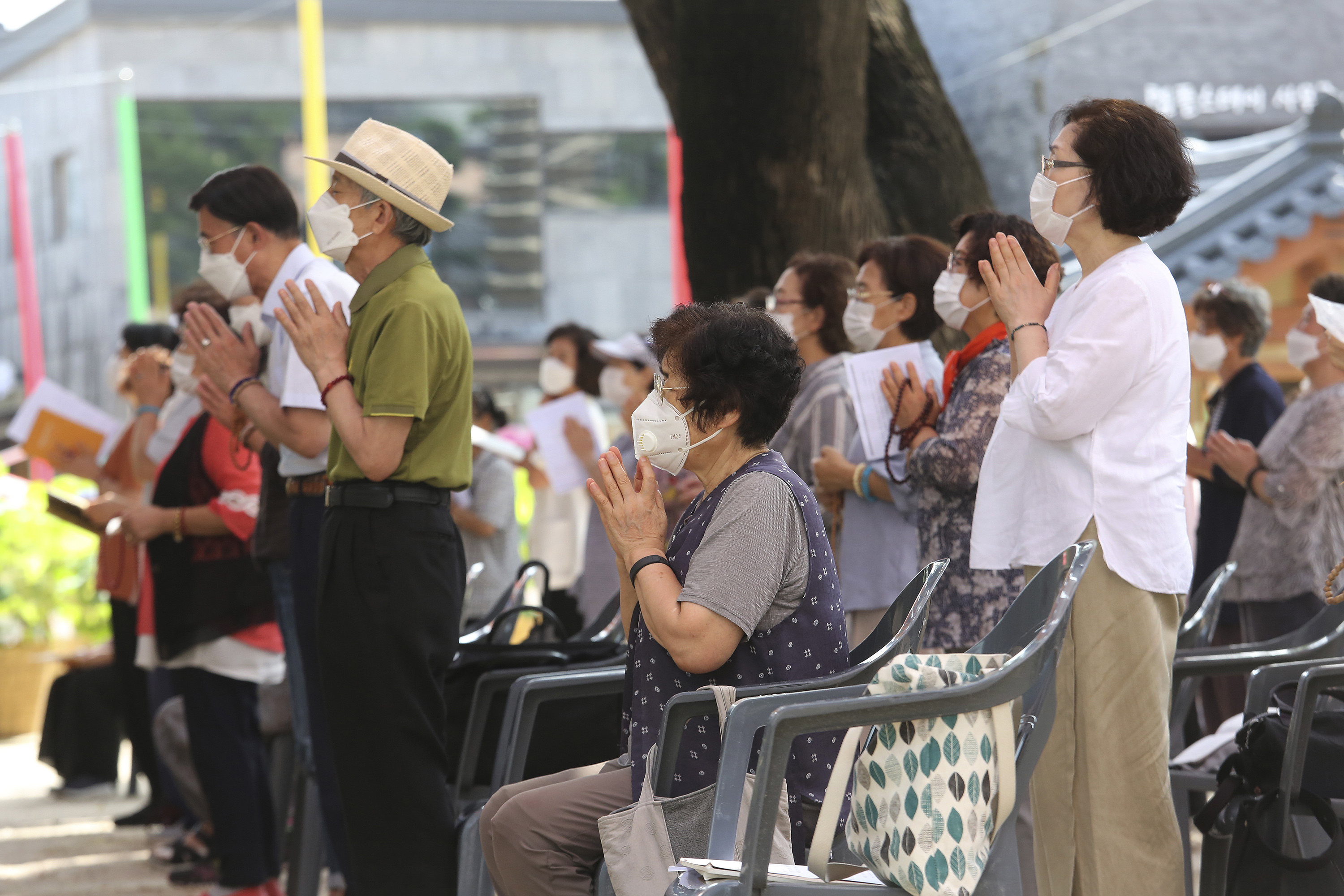 People wearing face masks to help protect against the spread of the coronavirus pray while maintaining social distancing during a service at the Chogyesa temple in Seoul, South Korea.