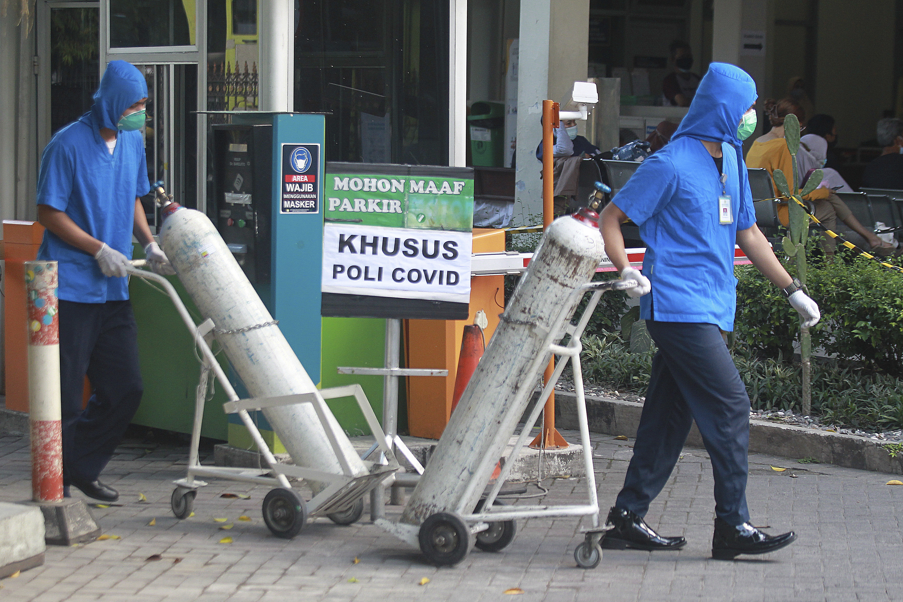 Medical workers wheel oxygen tanks at Dr. Sardjito Central Hospital in Yogyakarta, Indonesia, Sunday, July 4, 2021. (AP Photo/Kalandra)