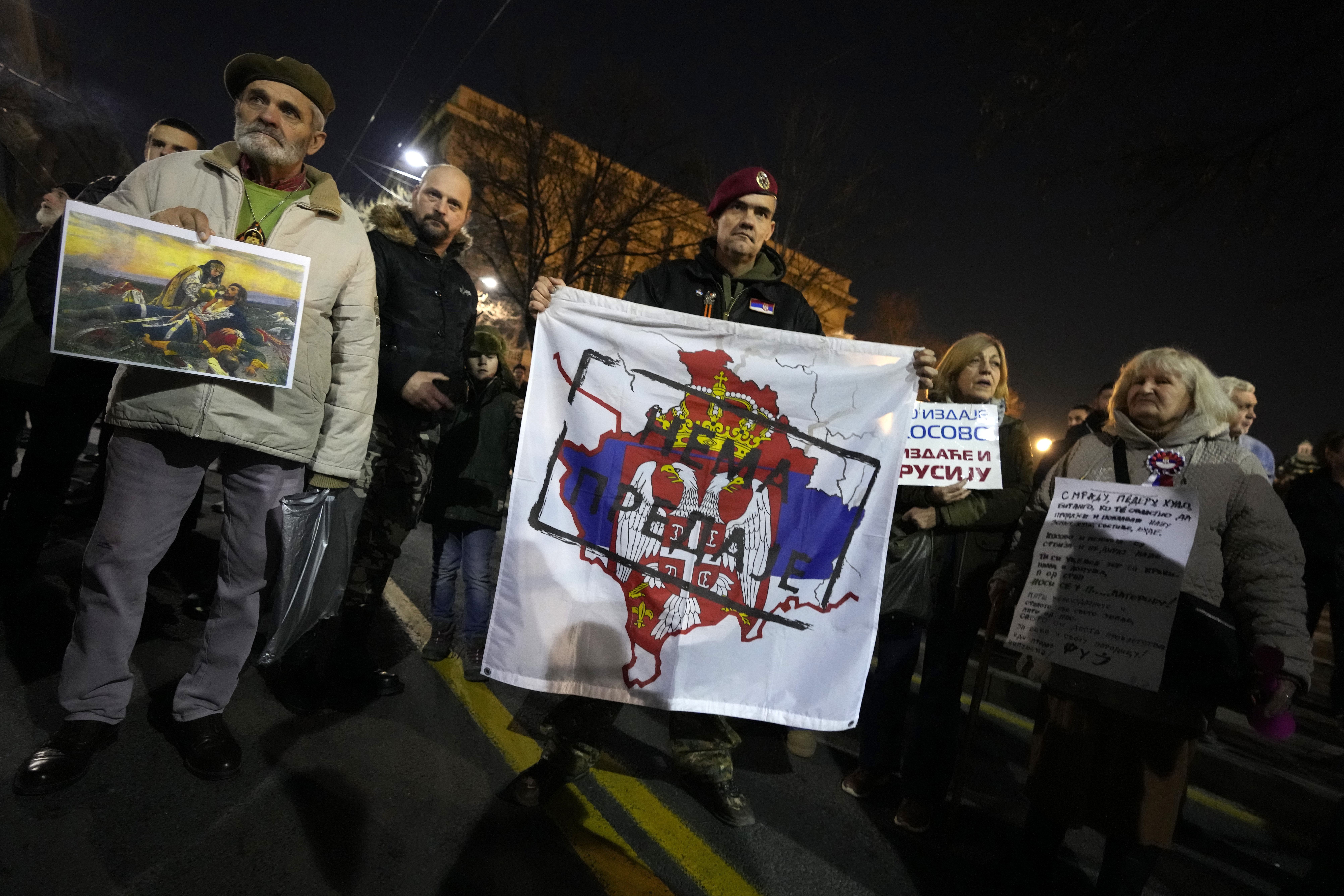 A man holds a banner that shows a map of Kosovo and Serbian coat of arms and flag reading: ''No surrender!'' during a protest against the Serbian authorities and French-German plan for the resolution of Kosovo, in Belgrade, Serbia, Wednesday, Feb. 15, 2023. Hundreds of pro-Russia nationalists have rallied outside the Serbian presidency building demanding that President Aleksandar Vucic reject a Western plan for normalization of ties with breakaway Kosovo and pull out of negotiations. Shouting Tr