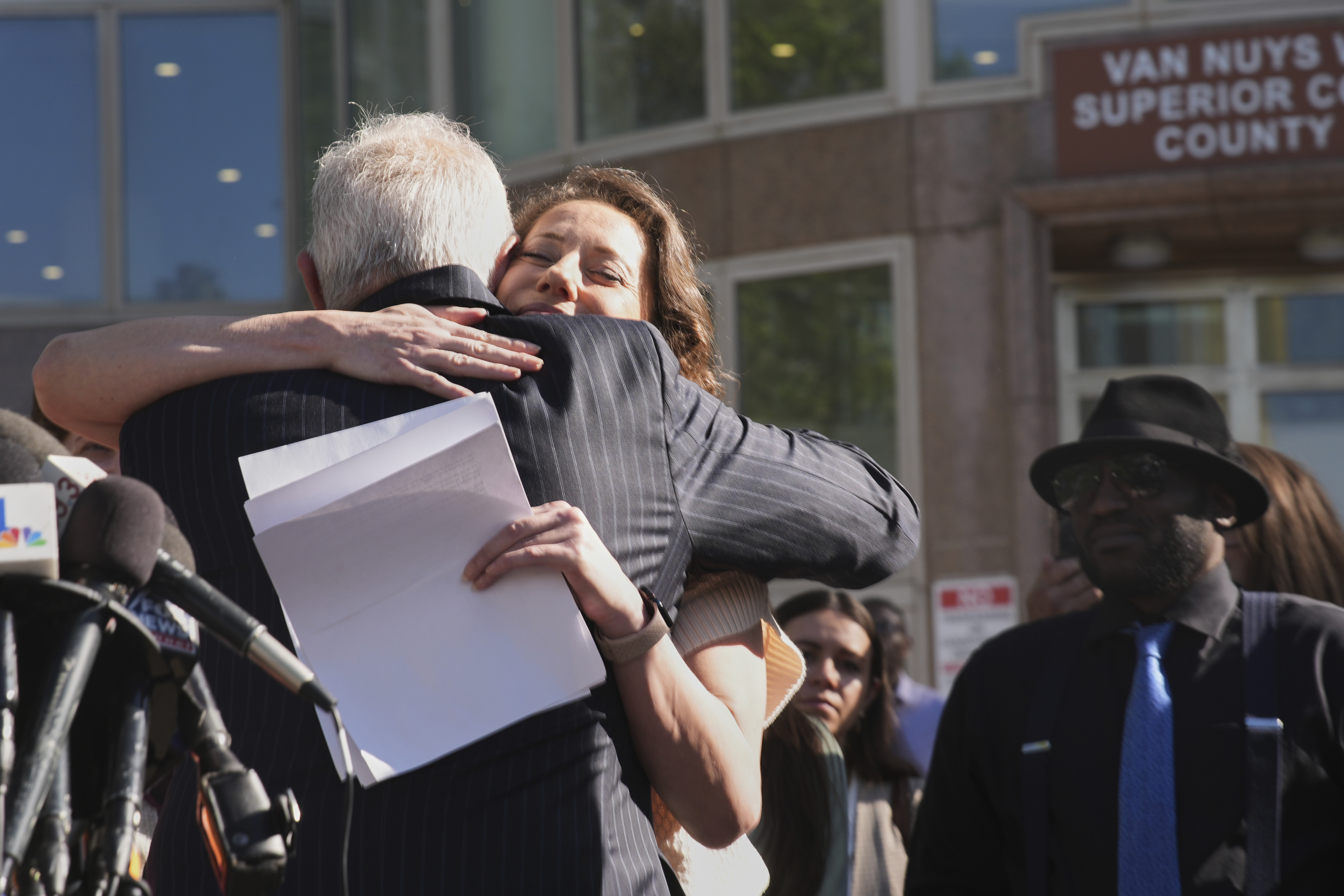 Anamaria Baralt, cousin of Erik and Lyle Menendez, hugs attorney Mark Geragos after a hearing in the brothers' case Friday, April 11, 2025, in Los Angeles. (AP Photo/Damian Dovarganes)
