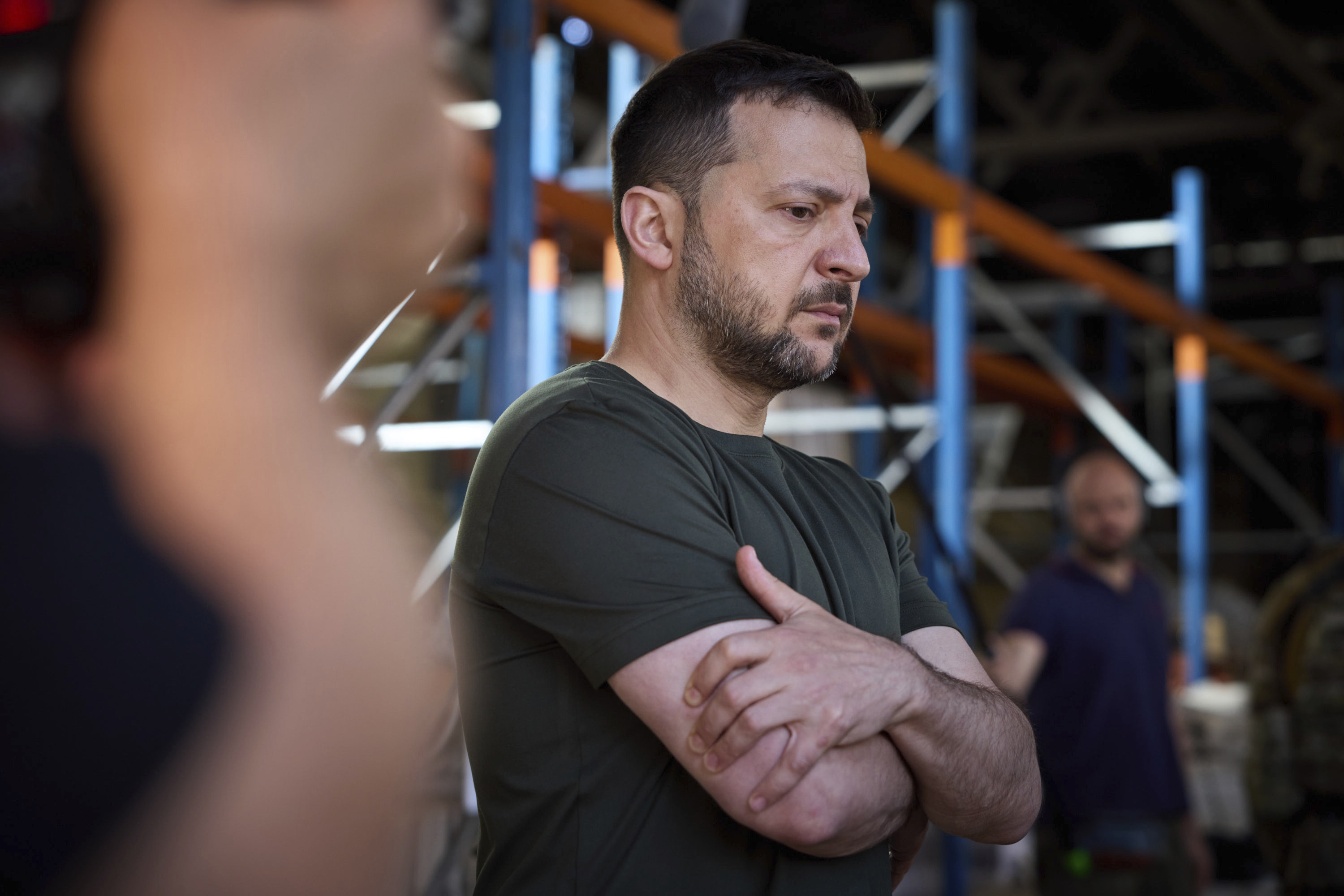 Ukraine's President Volodymyr Zelenskyy looks at burnt books in a damaged workshop of Ukraine's largest printing house ruined in Thursday deadly Russian missile attack that killed seven civilians in Kharkiv, Ukraine, Friday, May 24, 2024. 