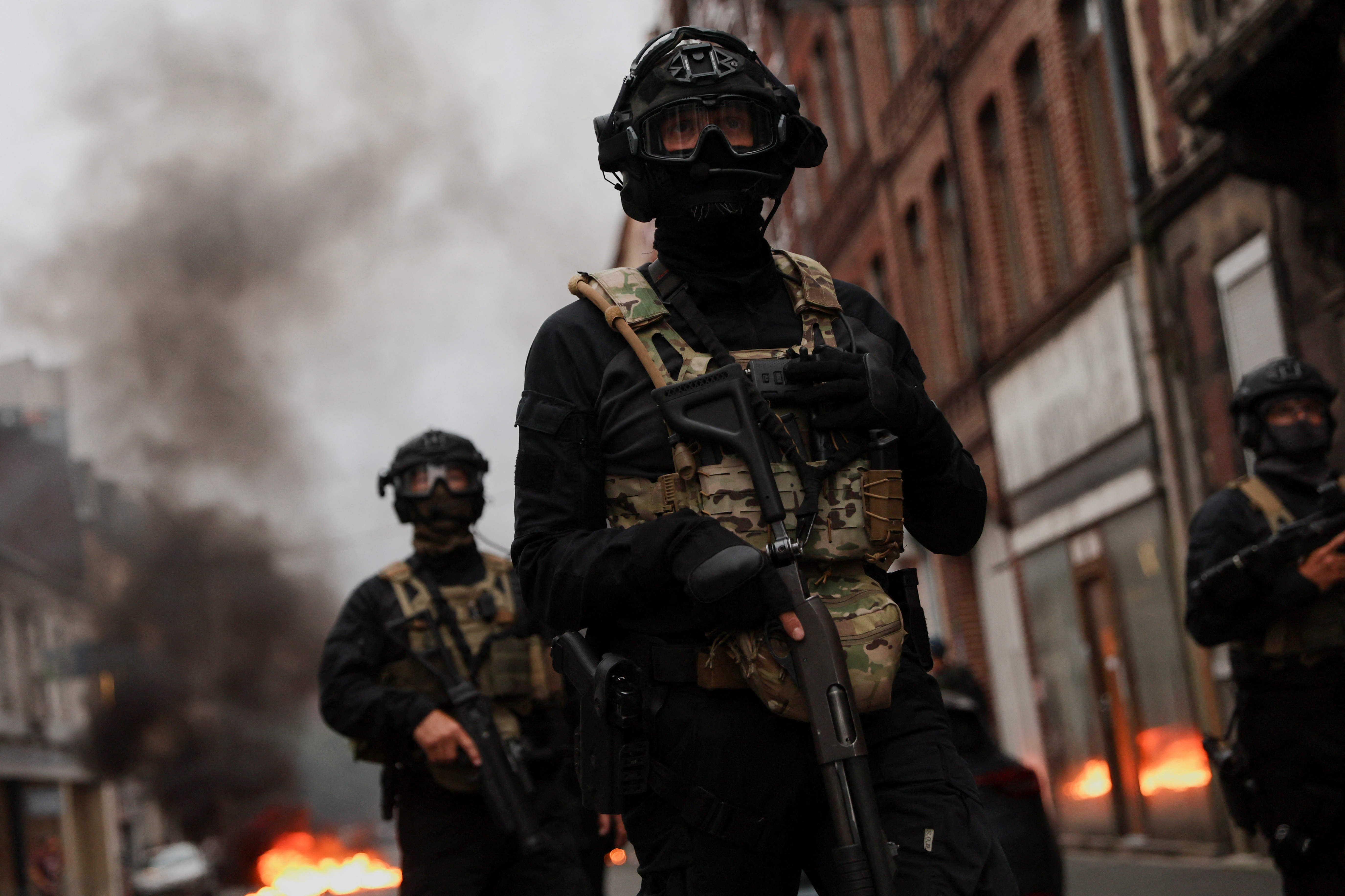 Officers stand guard during riots following the death of Nahel, a 17-year-old teenager killed by a French police officer in Nanterre during a traffic stop in Lille, France on Friday, June 30.