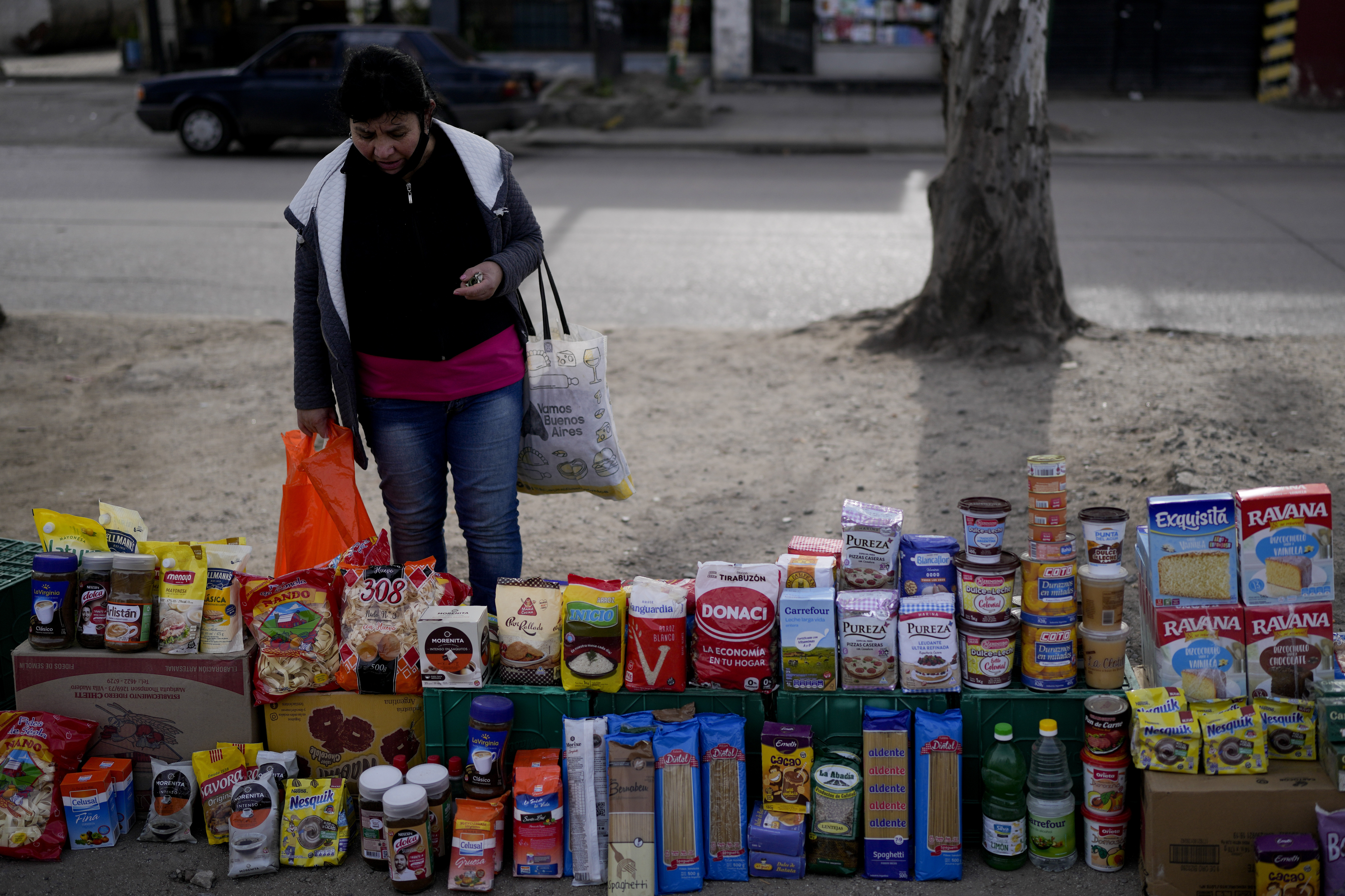A shopper looks at food displayed at a market where clients can buy or barter.