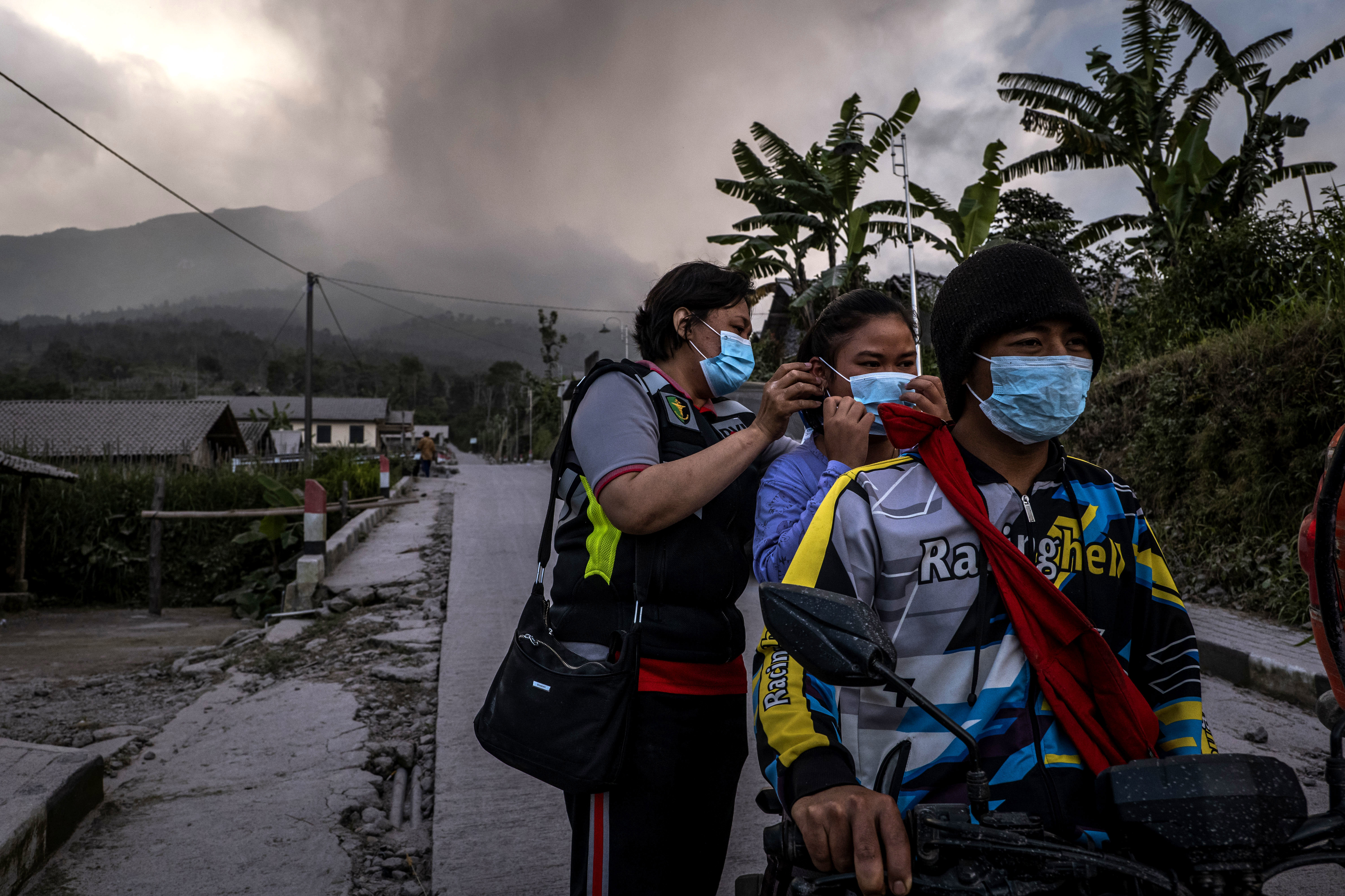 Officers distribute masks to villagers in an area covered by ash after Mount Merapi erupted spewing volcanic materials at Stabelan village on March 11, 2023 in Boyolali, Central Java, Indonesia.