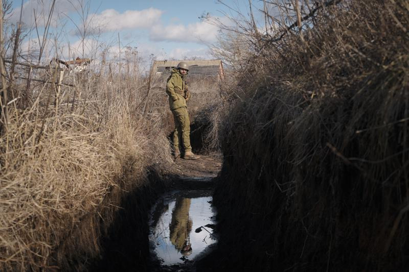 A Ukrainian serviceman pauses while walking to a frontline position outside Popasna, in the Luhansk region of eastern Ukraine. 