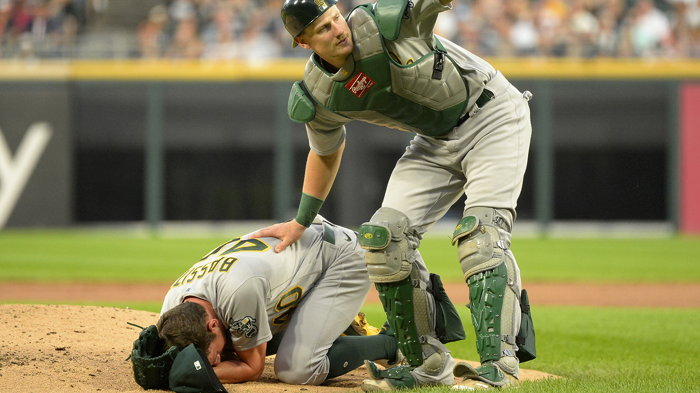 Catcher Sean Murphy calls for help after Chris Bassitt of the Oakland Athletics was hit in the face by a line drive off the bat of Brian Goodwin of the Chicago White Sox.