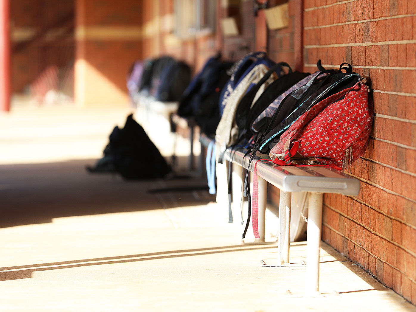 School bags lined up outside classroom.