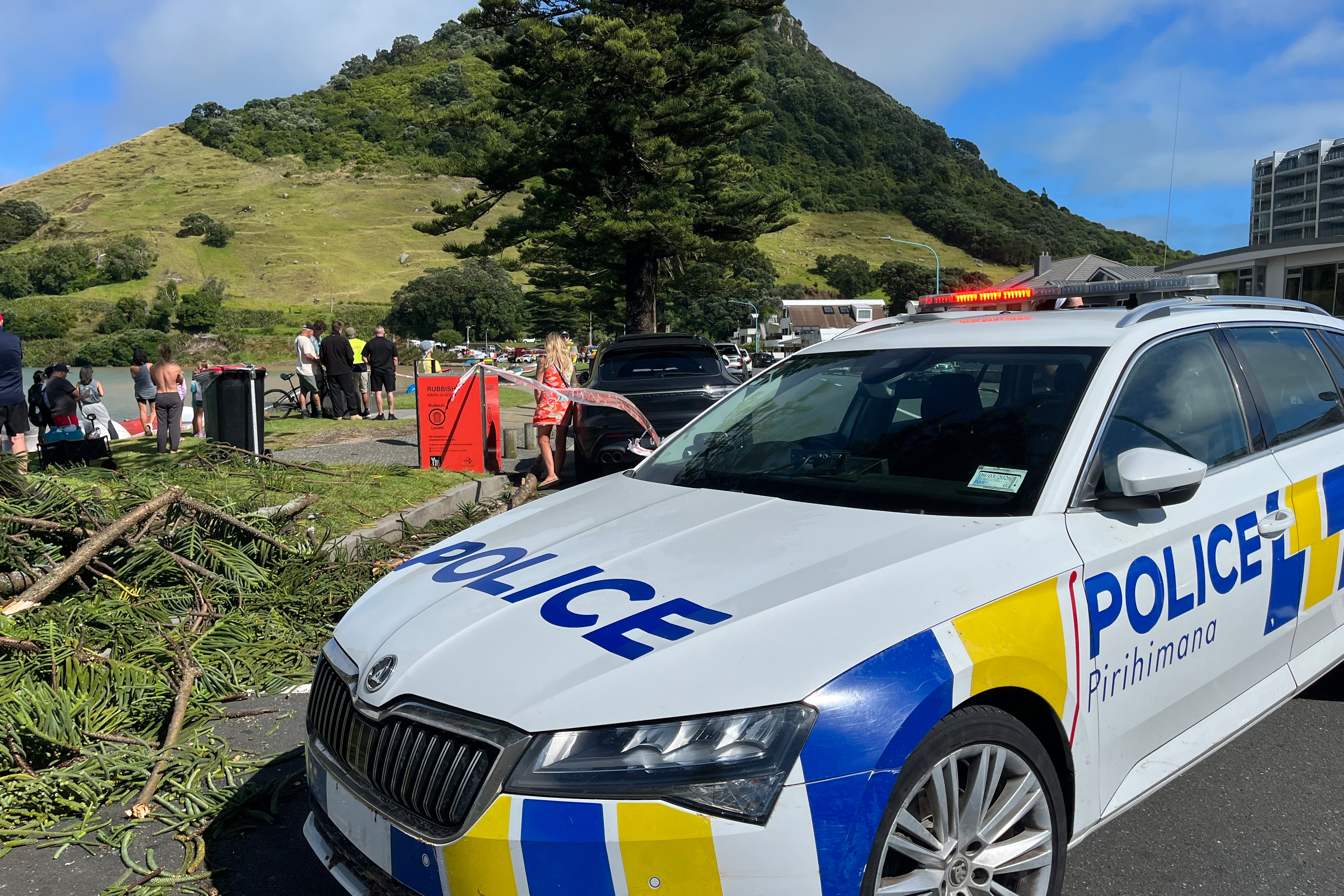 Emergency workers and bystanders survey the scene after a landslide hit a campground at Mt. Maunganui, New Zealand, Thursday, Jan. 22, 2026. 