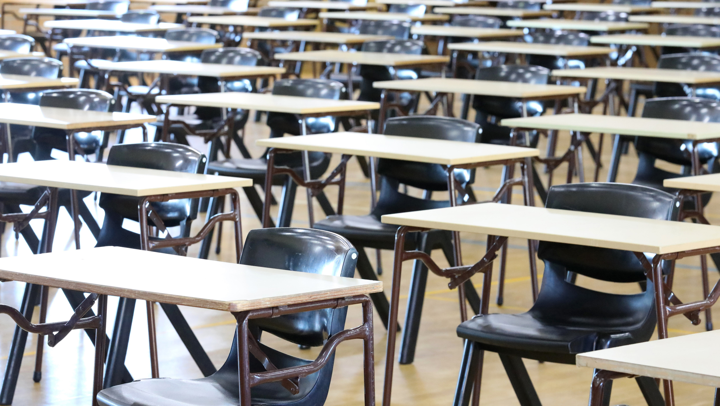 Multiple empty examination tables set up ready for Yr12 or Form 6 University entrance exams. school leavers certificate.