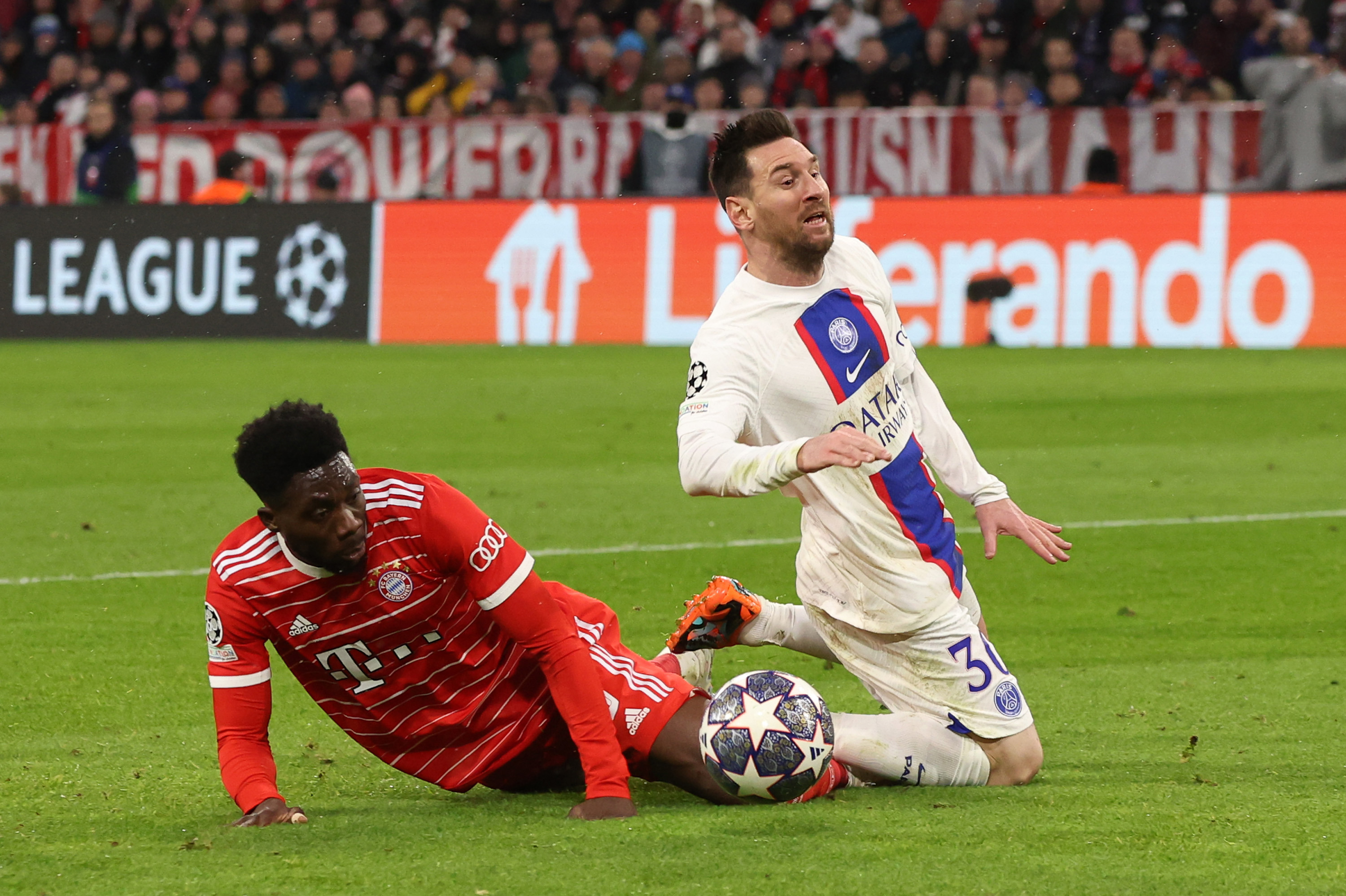 Lionel Messi of Paris Saint-Germain is tackled by Alphonso Davies of Bayern Munich.