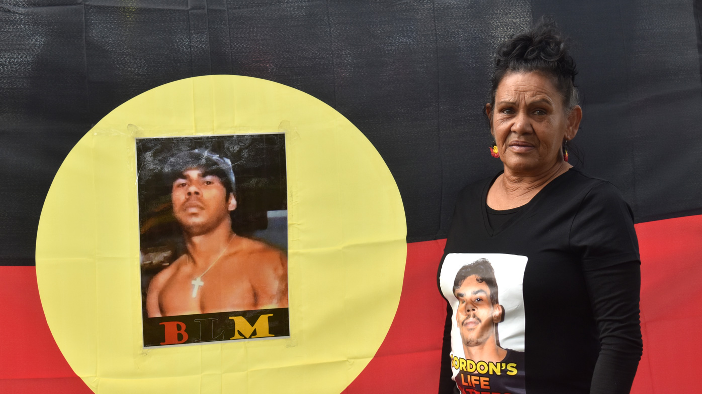 The mystery surrounding the disappearance of Gomeroi man Gordon Copeland has prompted community action. Stella Fernando stands next to a photo of her missing grandson, Gordon.
