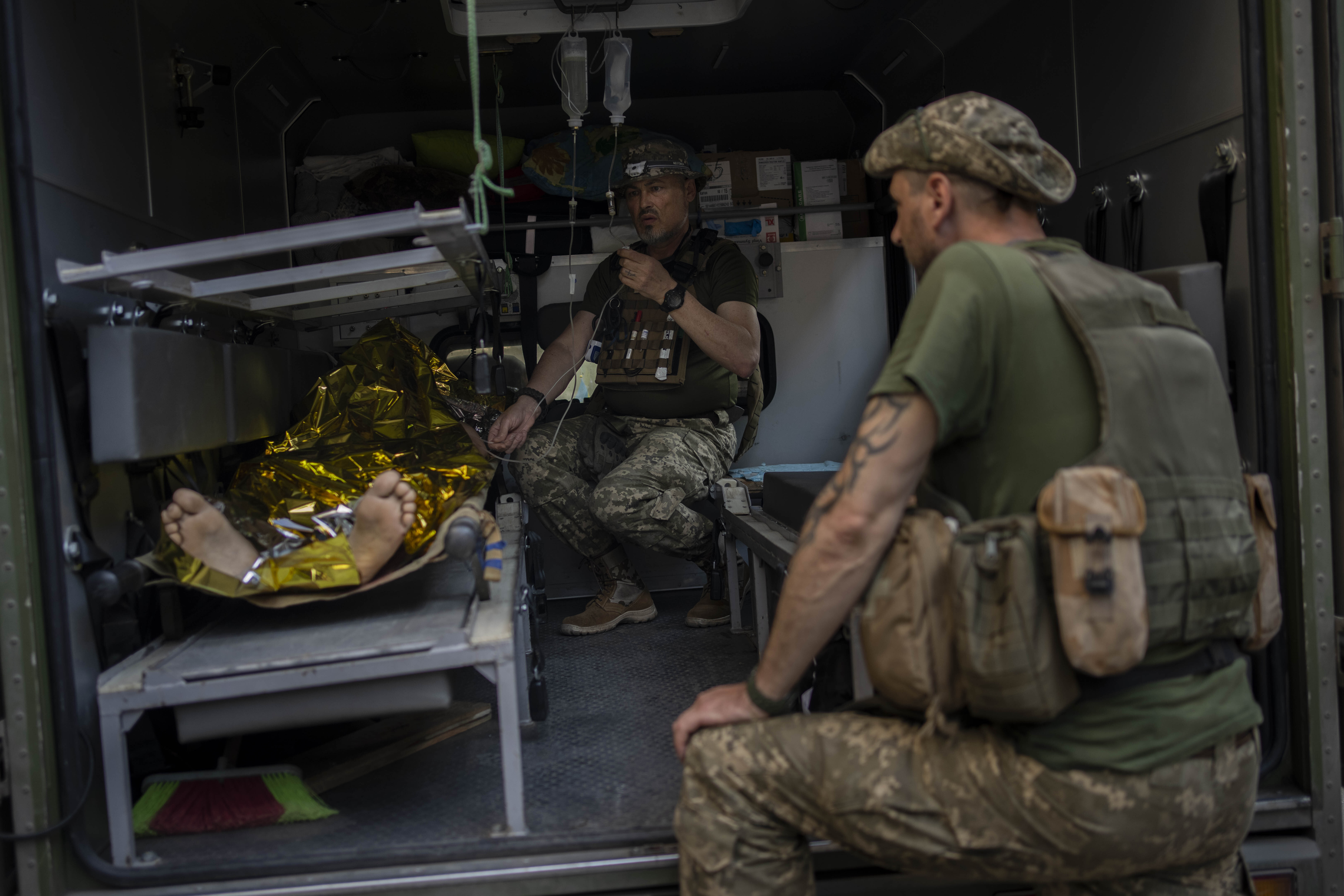 An injured Ukrainian servicemen is transferred to a medical facility after getting an emergency medical treatment in the Donetsk region, eastern Ukraine, Tuesday, June 7, 2022.