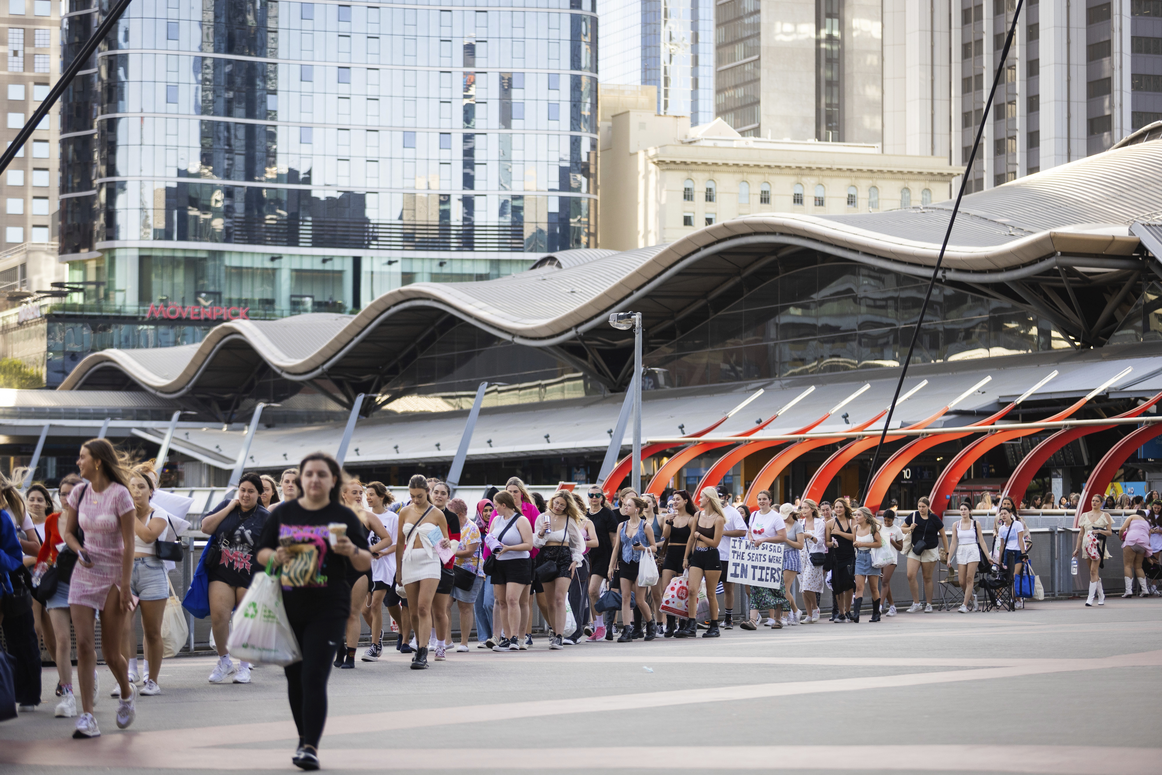 A long line of fans is seen stretching around the Southern Cross Station Concourse to Marvel Stadium in the lead up to the Harry Styles concert.