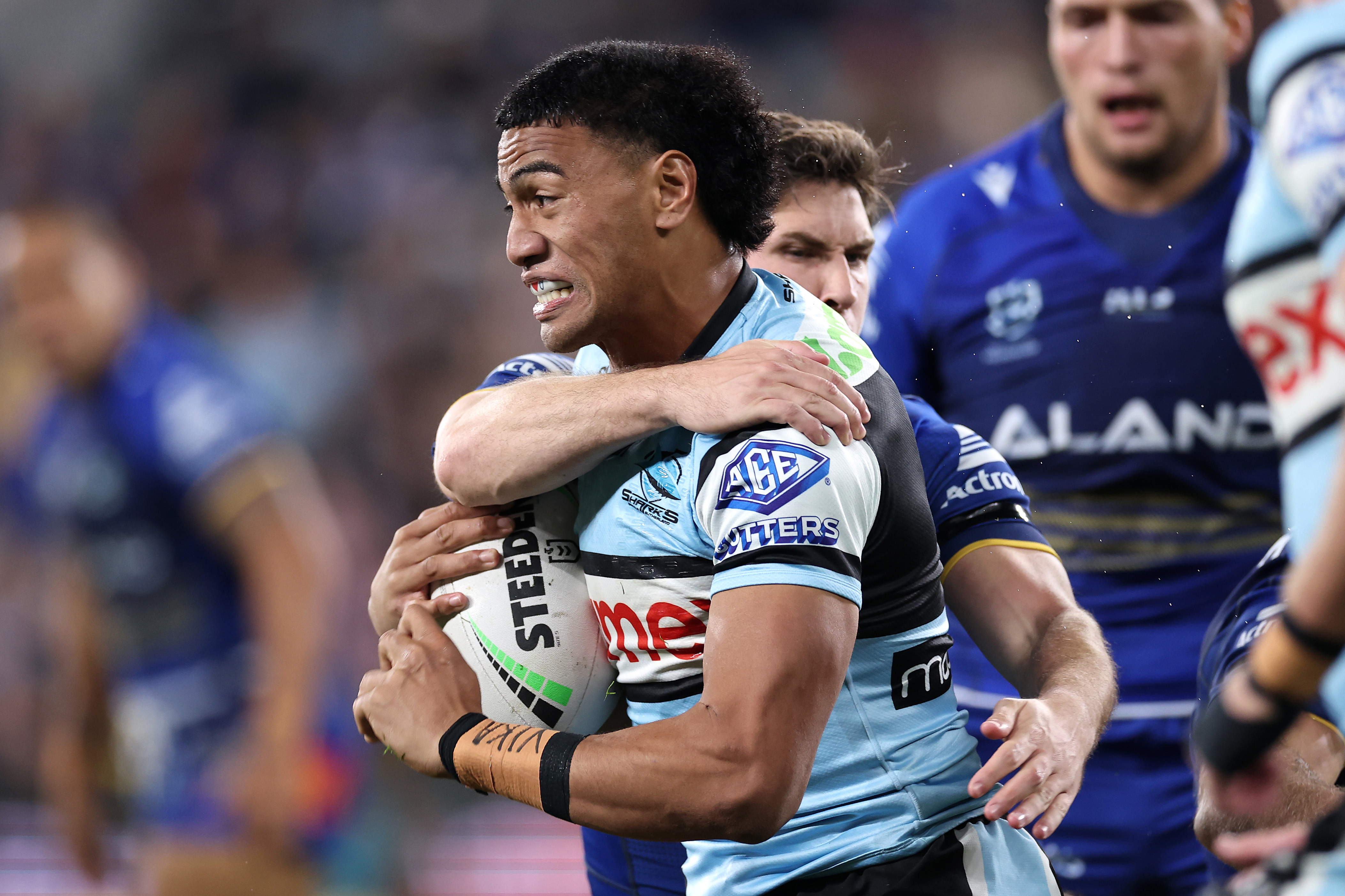 Ronaldo Mulitalo of the Sharks is tackled by Mitchell Moses of the Eels.