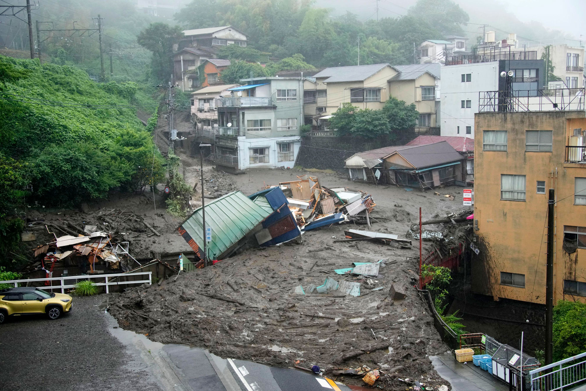 Houses are damaged by mudslide following heavy rain at Izusan district in Atami, west of Tokyo, Saturday, July 3, 2021. 