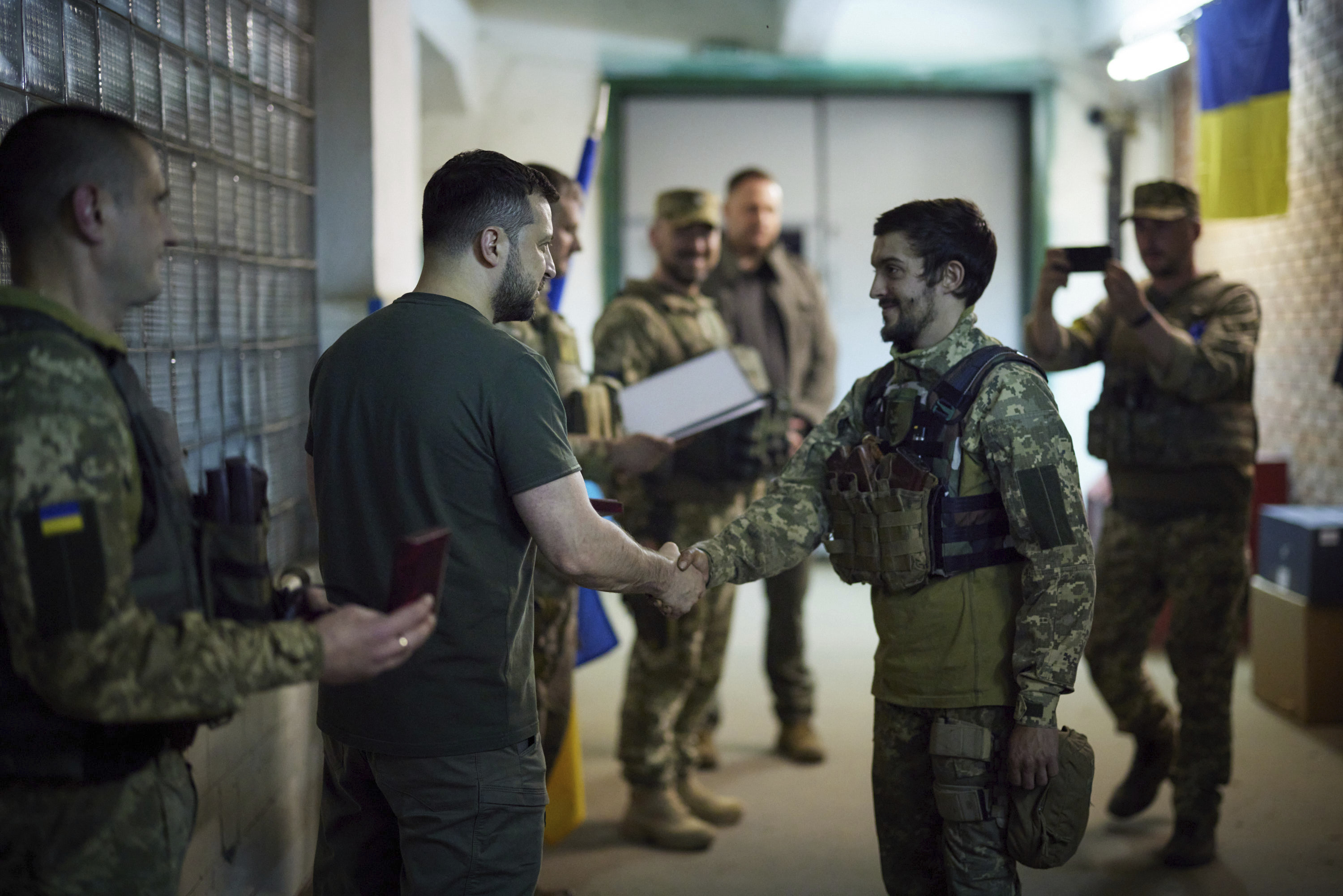 In this photo provided by the Ukrainian Presidential Press Office, Ukrainian President Volodymyr Zelenskyy, left, awards servicemen close to the front line in Donetsk region, Ukraine, Sunday, June 5, 2022. (Ukrainian Presidential Press Office via AP)