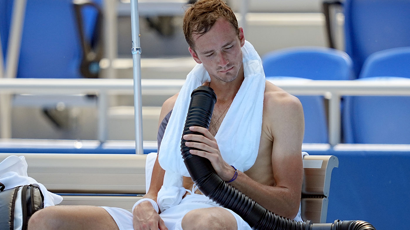 Daniil Medvedev cools down during the break with air from a mobile air conditioner and a towel with ice cubes. Photo: Michael Kappeler/dpa (Photo by Michael Kappeler/picture alliance via Getty Images)