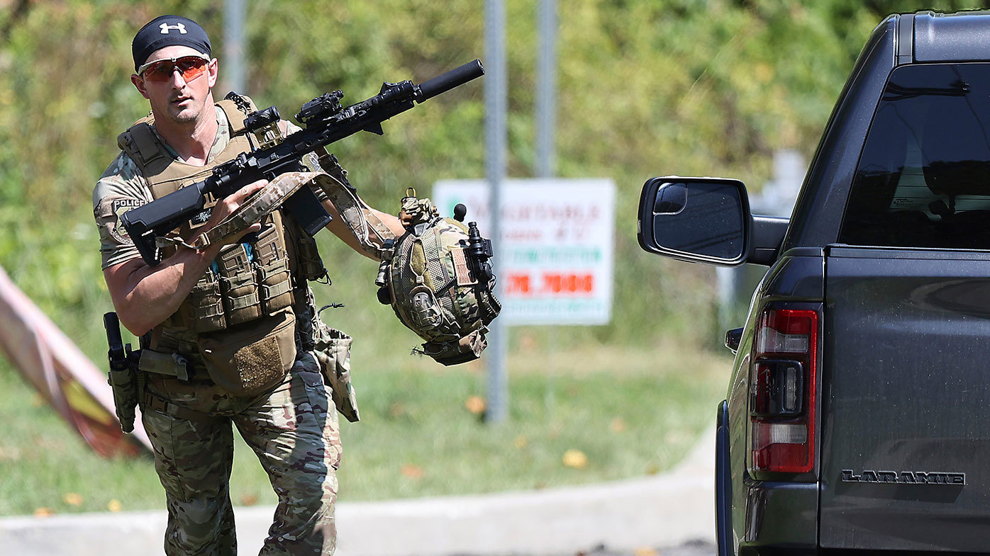 A heavily armed law enforcement officer runs on a potential sighting of Danelo Cavalcante in Pocopson Township, Pennsylvania.