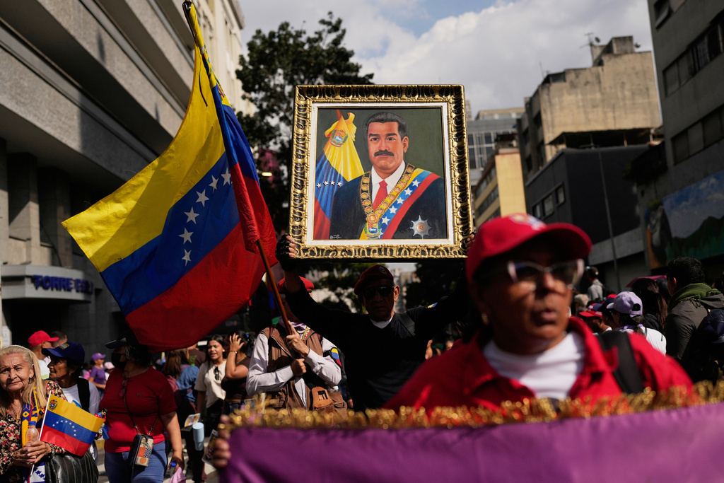 A government supporter holds an image of President Nicolas Maduro