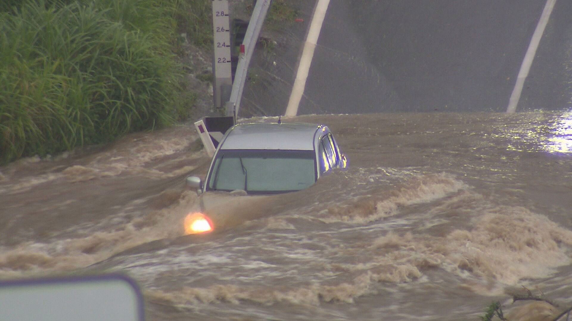 A car is overwhelmed by water while trying to cross a submerged road.