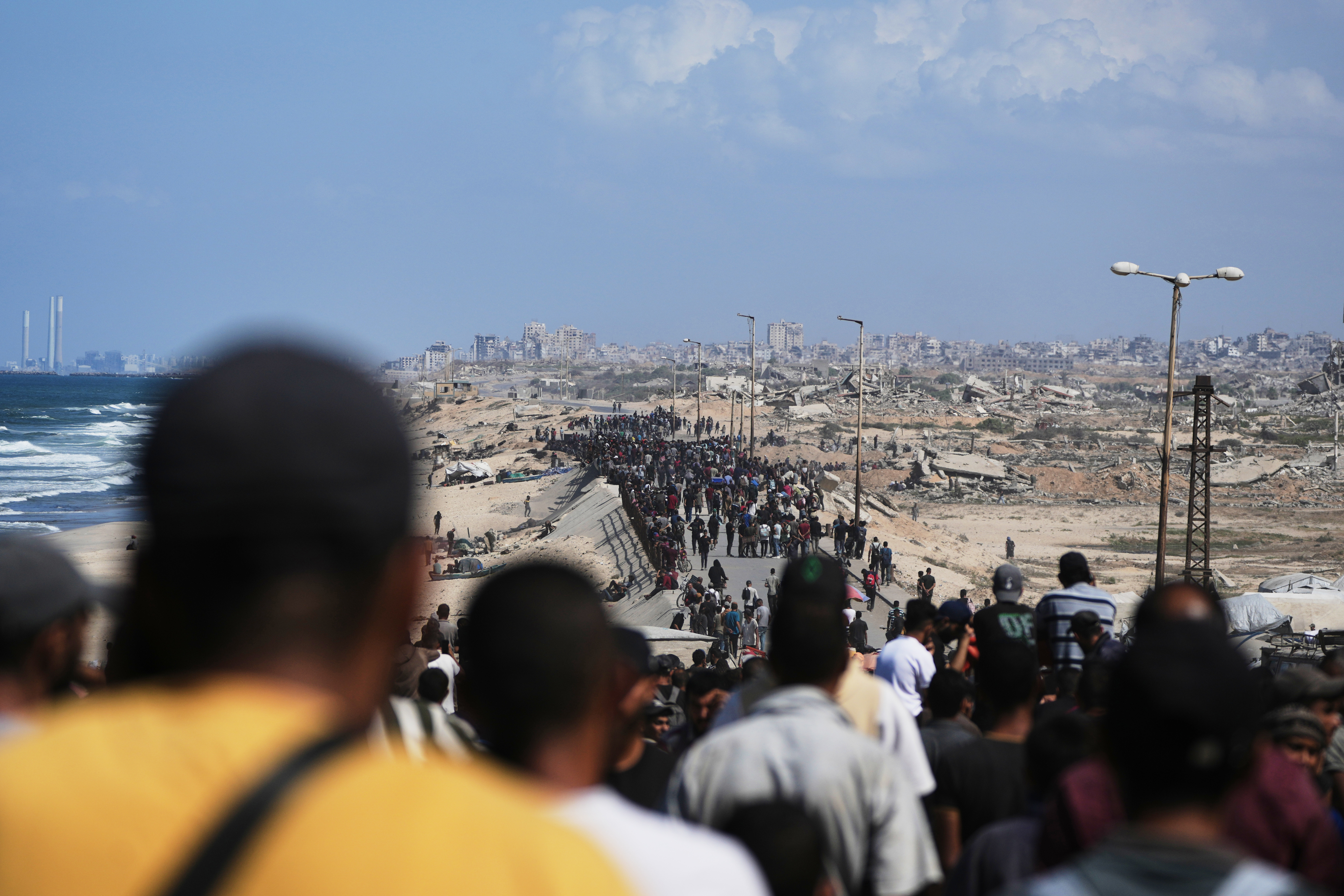 Displaced Palestinians walk along the coastal road near Wadi Gaza in the central Gaza Strip