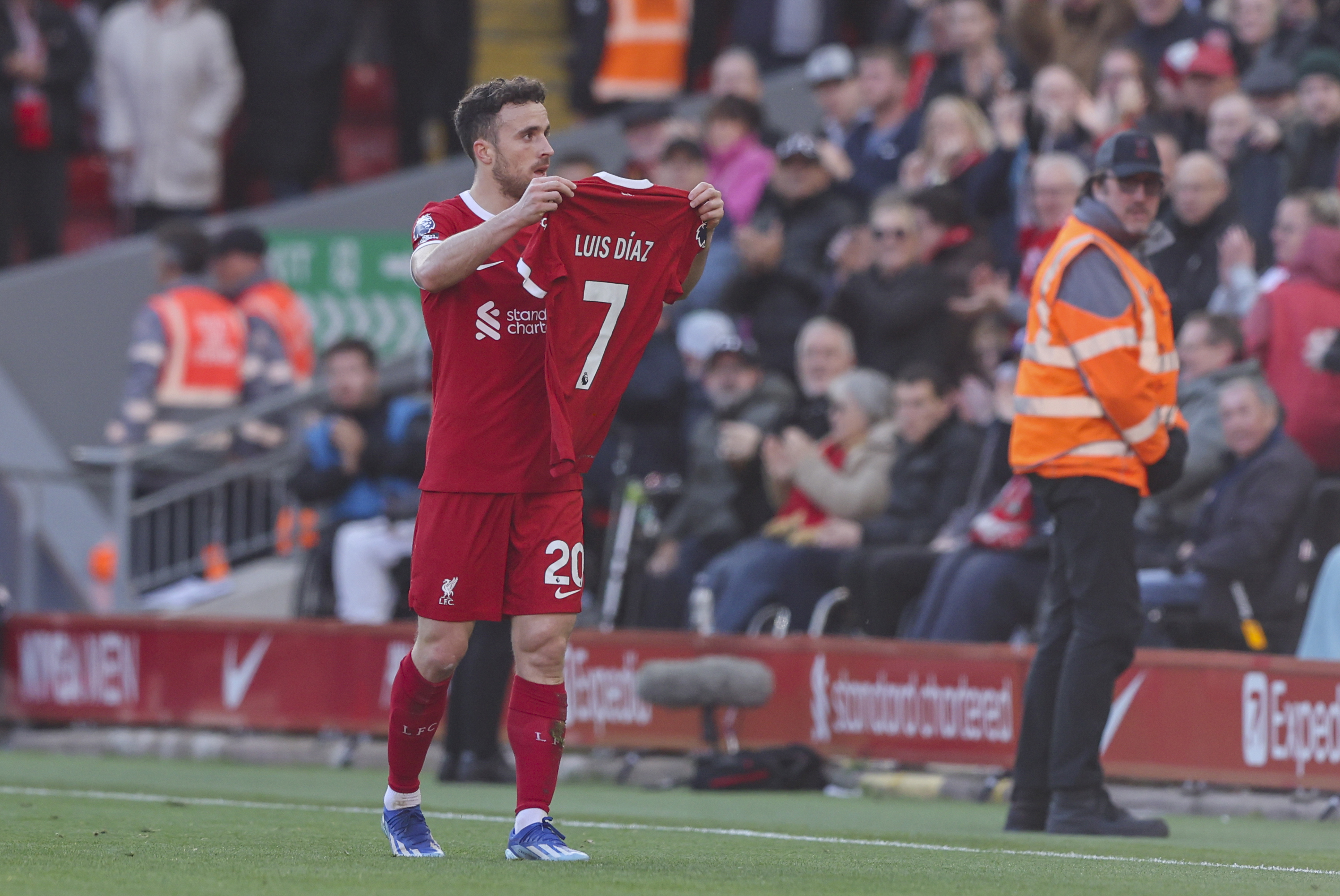 Liverpool's Diogo Jota holds up the shirt of teammate Luis Diaz in tribute.