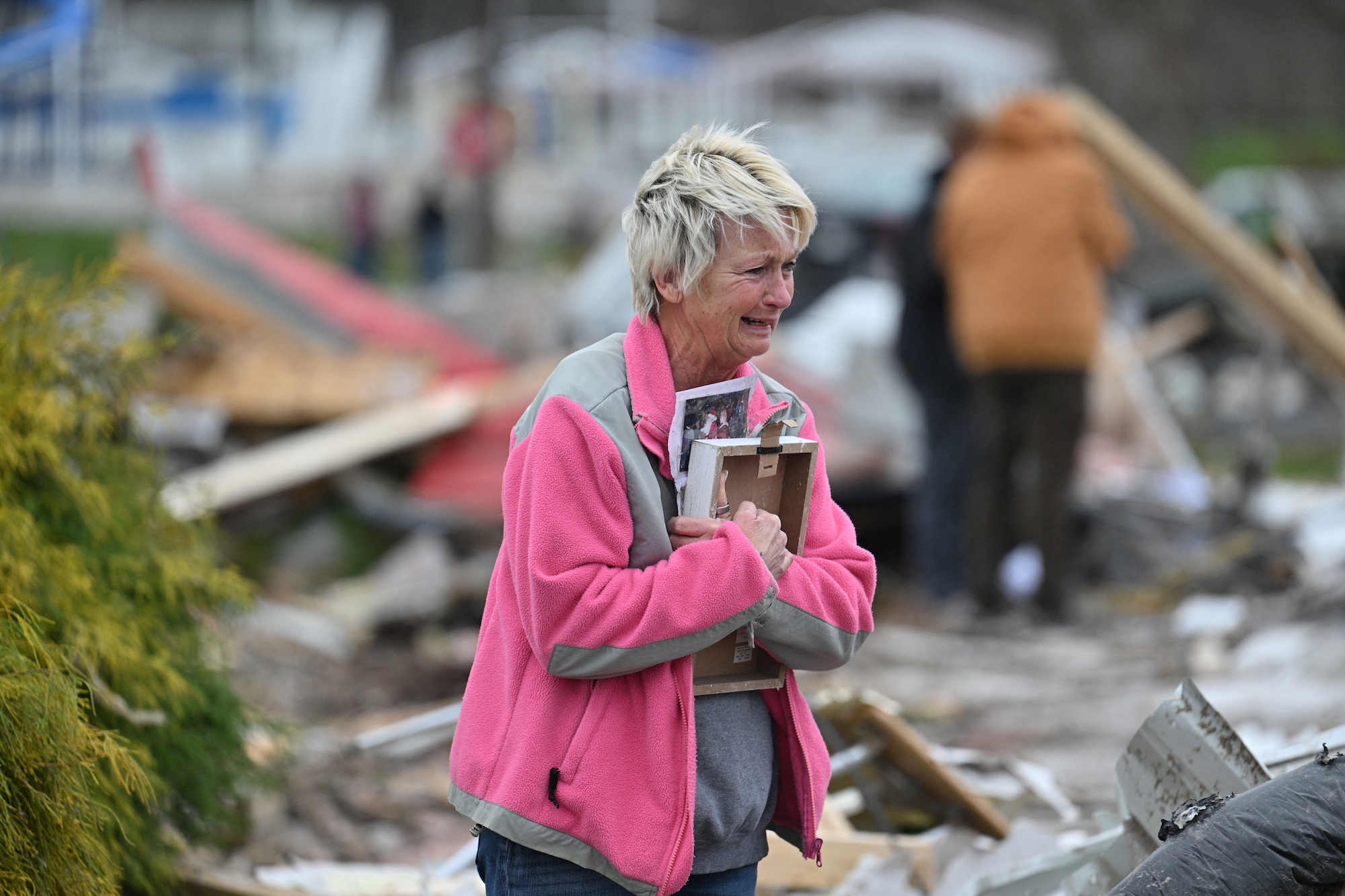 Debbie Lowdermilk sostiene fotografías mientras reacciona mientras observa la escuela destruida de la que es dueña el día después de que un tornado azotara Sullivan, Indiana, EE. UU., el 1 de abril de 2023.  