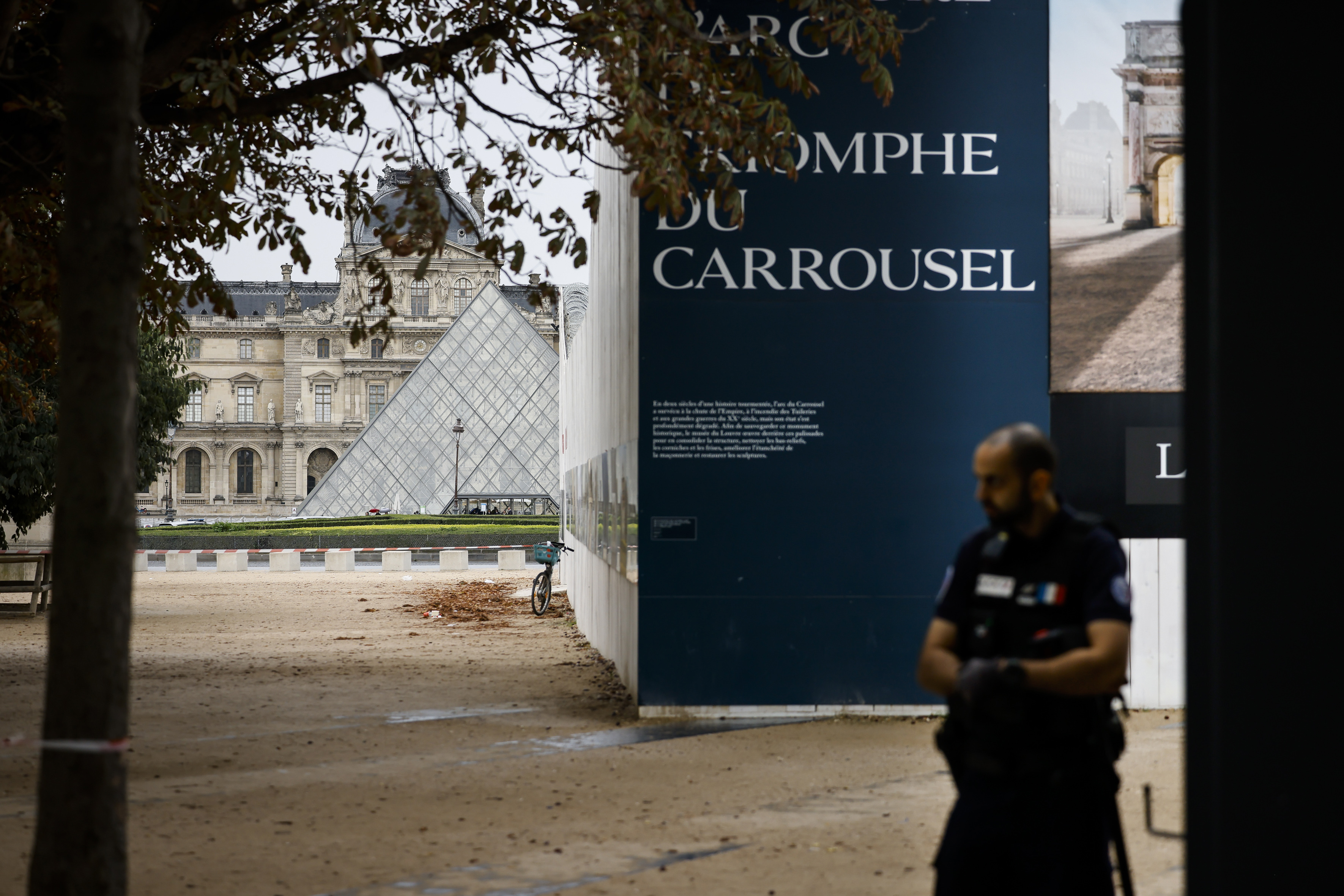 A police officer stand guard outside the Louvre Museum as people are evacuated after it received a written threat, in Paris, Saturday Oct. 14, 2023. 