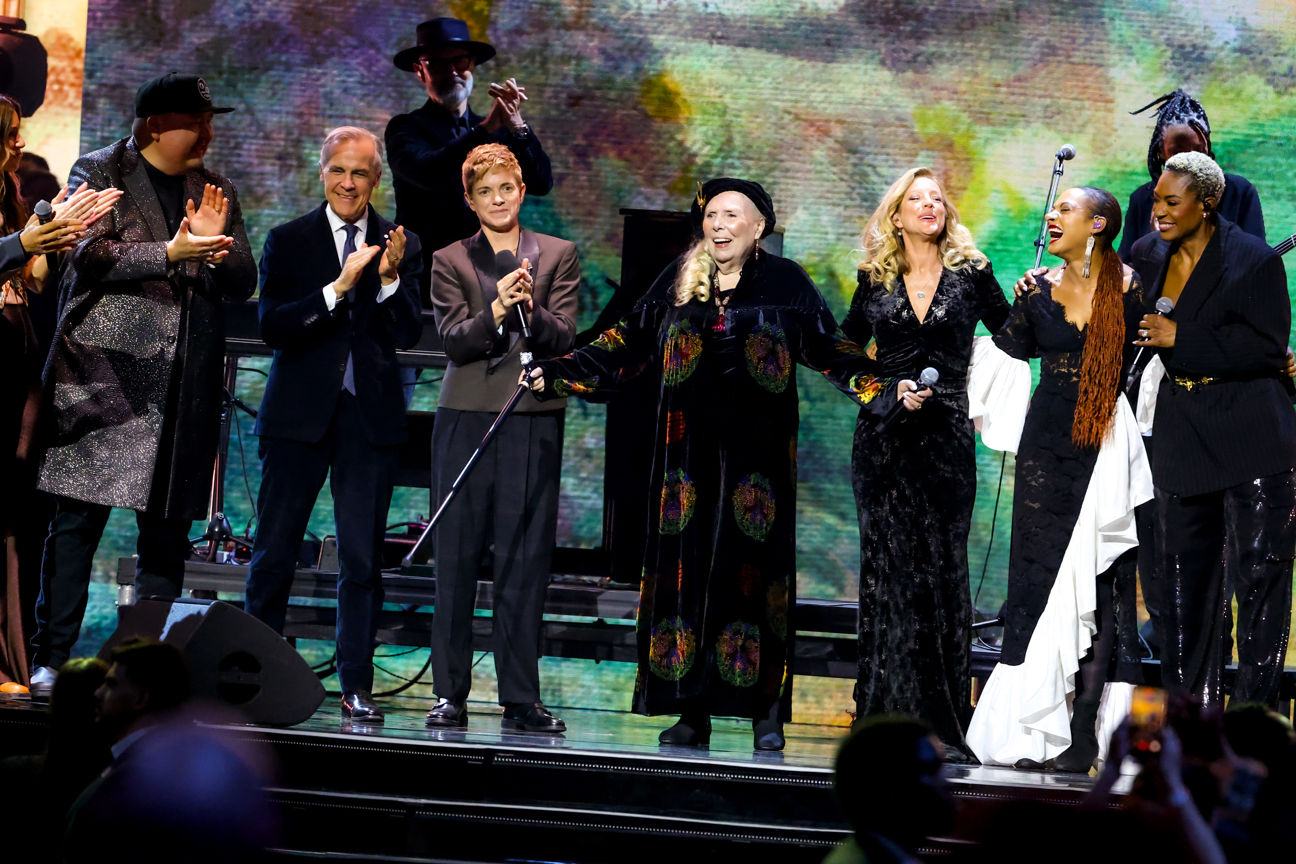 HAMILTON, ONTARIO - MARCH 29: (L-R) William Prince, Prime Minister of Canada Mark Carney, Mae Martin, Joni Mitchell, Sarah McLachlan, Allison Russell and Jully Black perform onstage during the 2026 JUNO Awards at TD Coliseum on March 29, 2026 in Hamilton, Ontario. (Photo by Cindy Ord/Getty Images)
