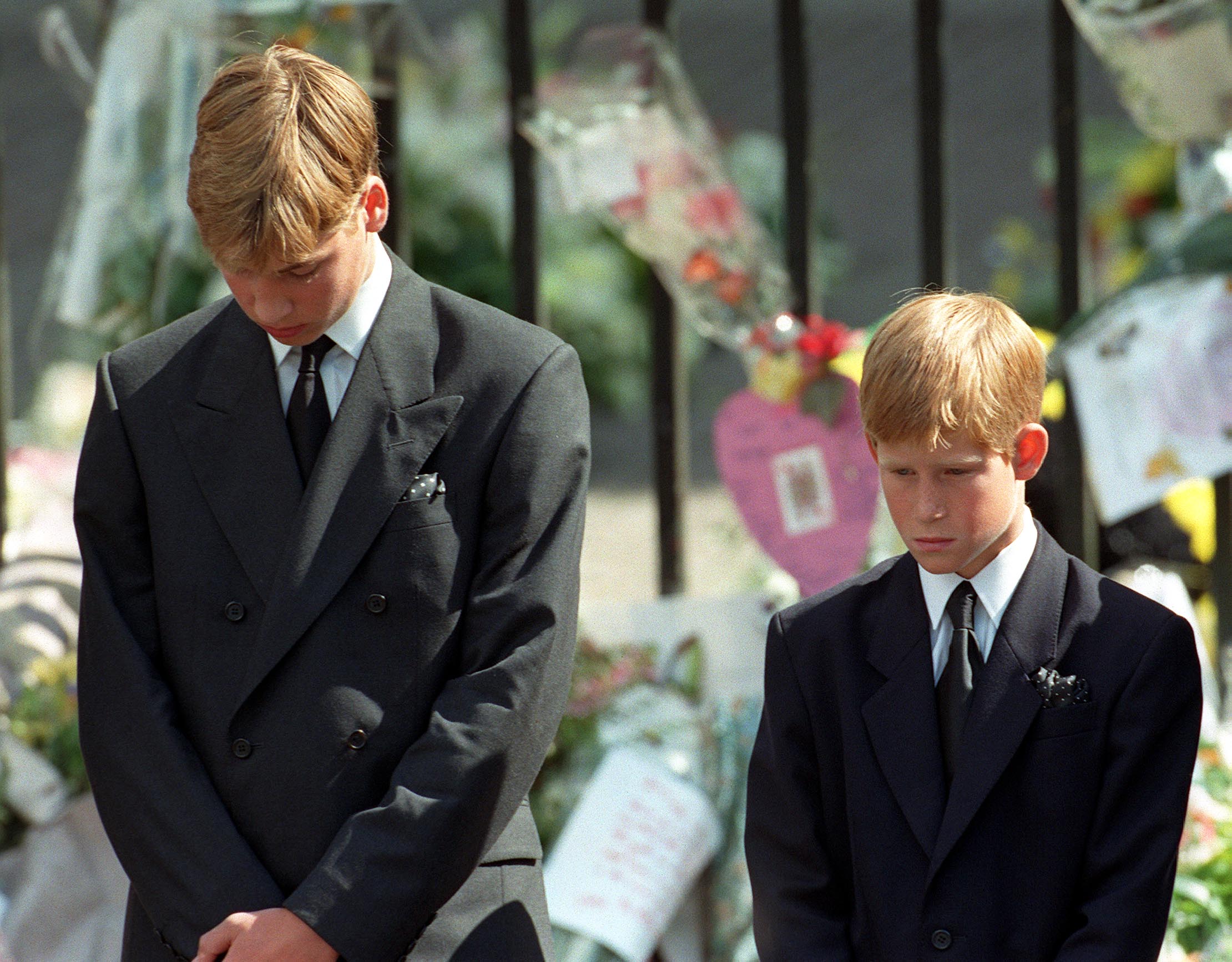Prince William (left) and Prince Harry, the sons of Diana, Princess of Wales, bow their heads as their mother's coffin is taken out of Westminster Abbey following her funeral service. 