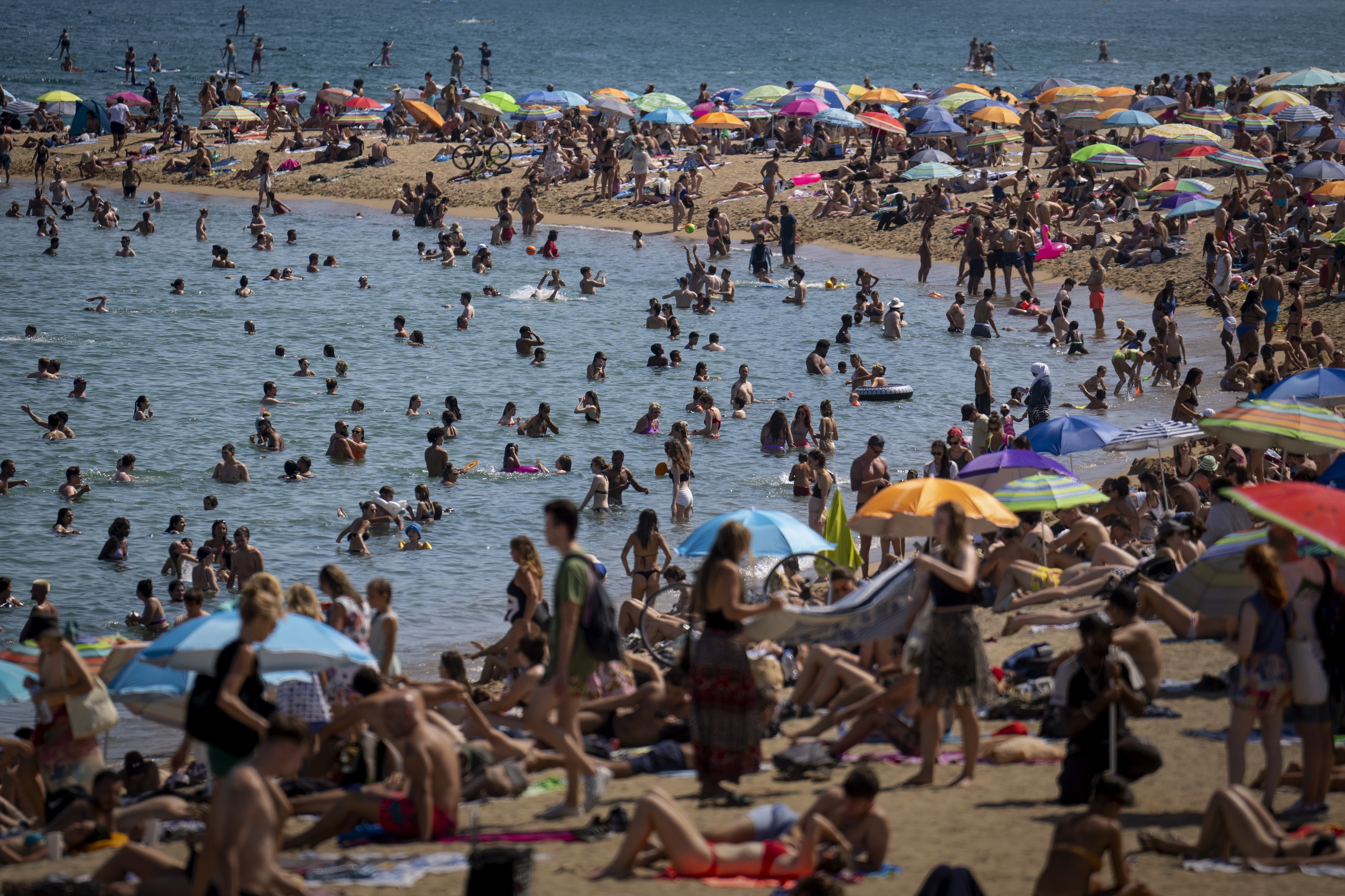 People cool off in the water on a hot and sunny day at the beach in Barcelona, Spain, July 15, 2022. 