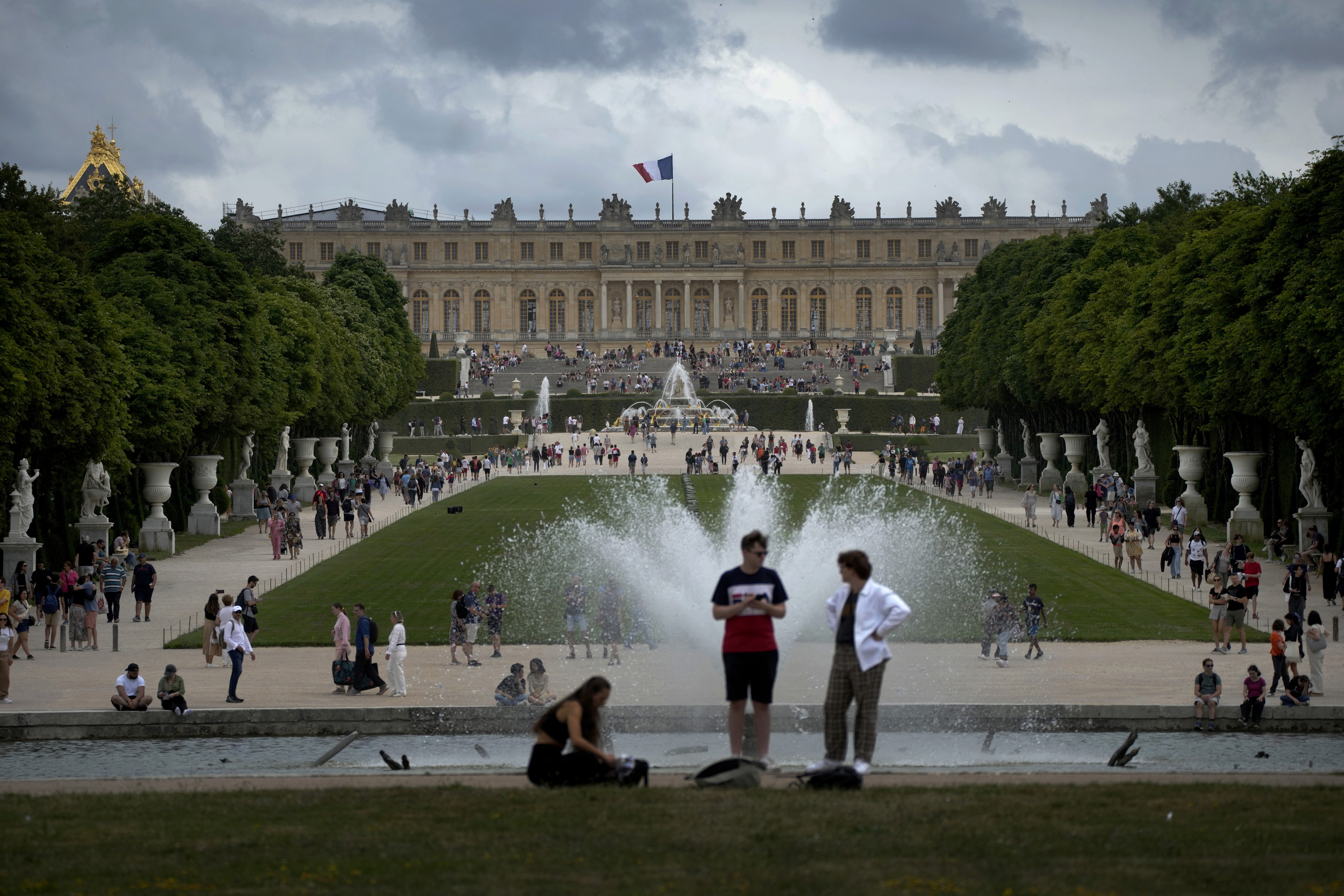 Visitors enjoy the Chateau de Versailles gardens, outside Paris, France, on July 15, 2023. 