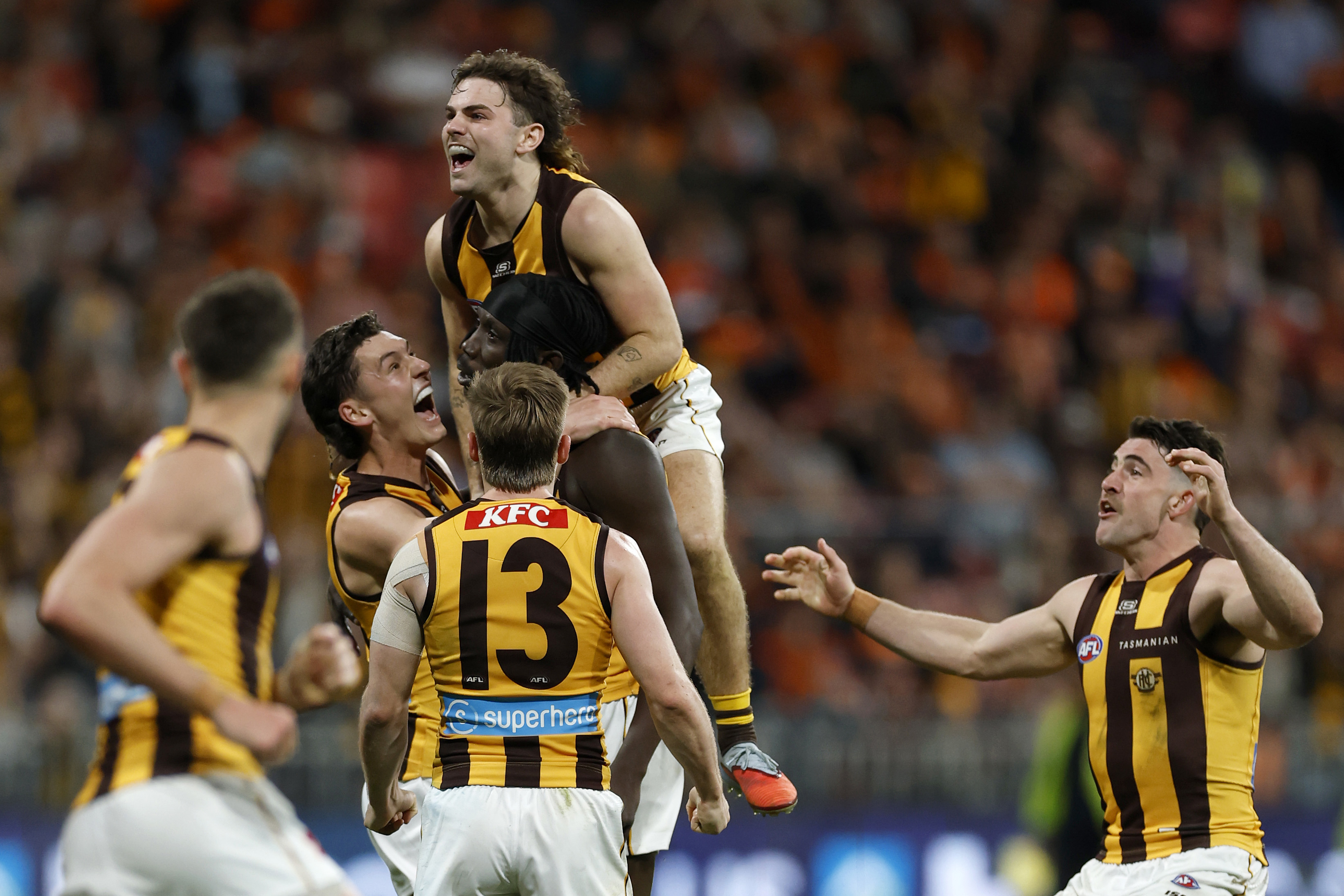 Mabior Chol of the Hawks is congratulated by teammates after kicking a goal.