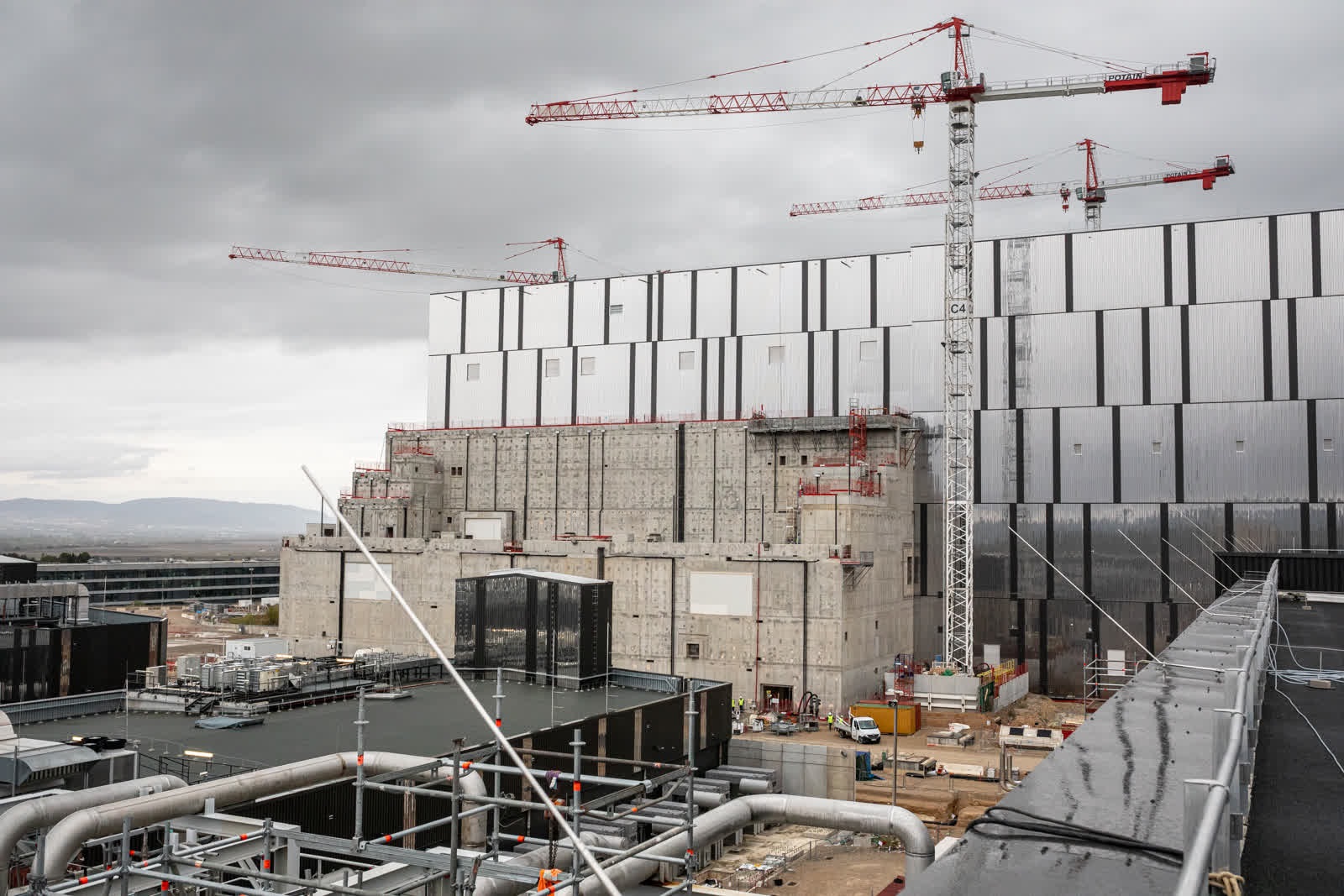 The black platform in the lower part of the frame is the tokamak complex, a 400,000-ton edifice that brings together the tokamak, diagnostics and tritium buildings. 
