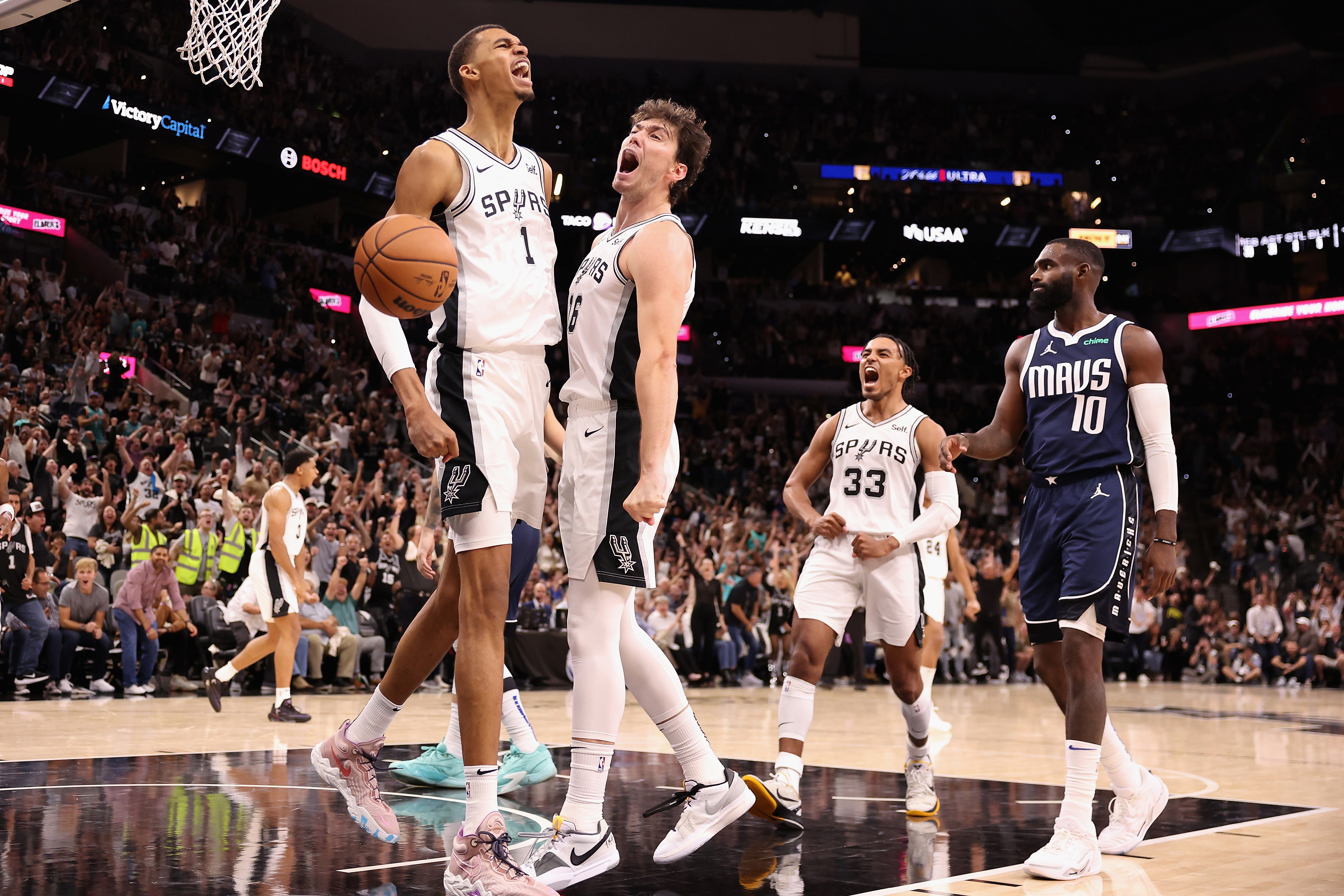 SAN ANTONIO, TEXAS - OCTOBER 25: Victor Wembanyama #1 of the San Antonio Spurs celebrates with Cedi Osman #16 after a slam dunk against the Dallas Mavericks during the fourth quarter of the NBA game at Frost Bank Center on October 25, 2023 in San Antonio, Texas.  The Mavericks defeated the Spurs 126-119. 