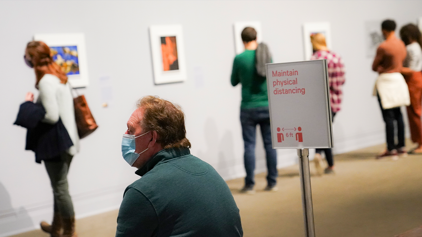 Visitors wearing protective masks observe COVID-19 prevention protocols as they browse the Jacob Lawrence: The American Struggle exhibition at the Metropolitan Museum of Art, Saturday, Oct. 17, 2020, in New York. (AP Photo/John Minchillo)