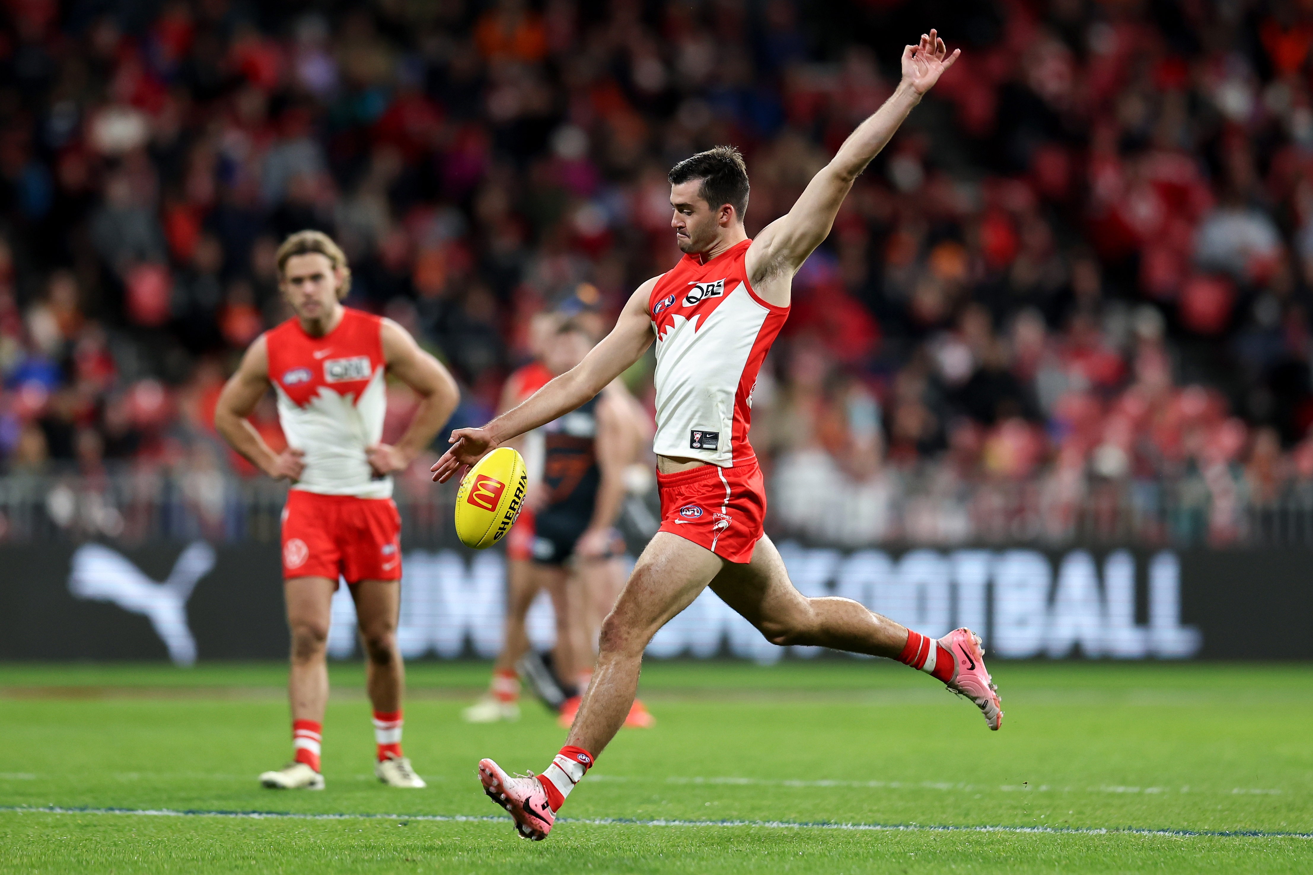 Logan McDonald of the Swans kicks for goal.