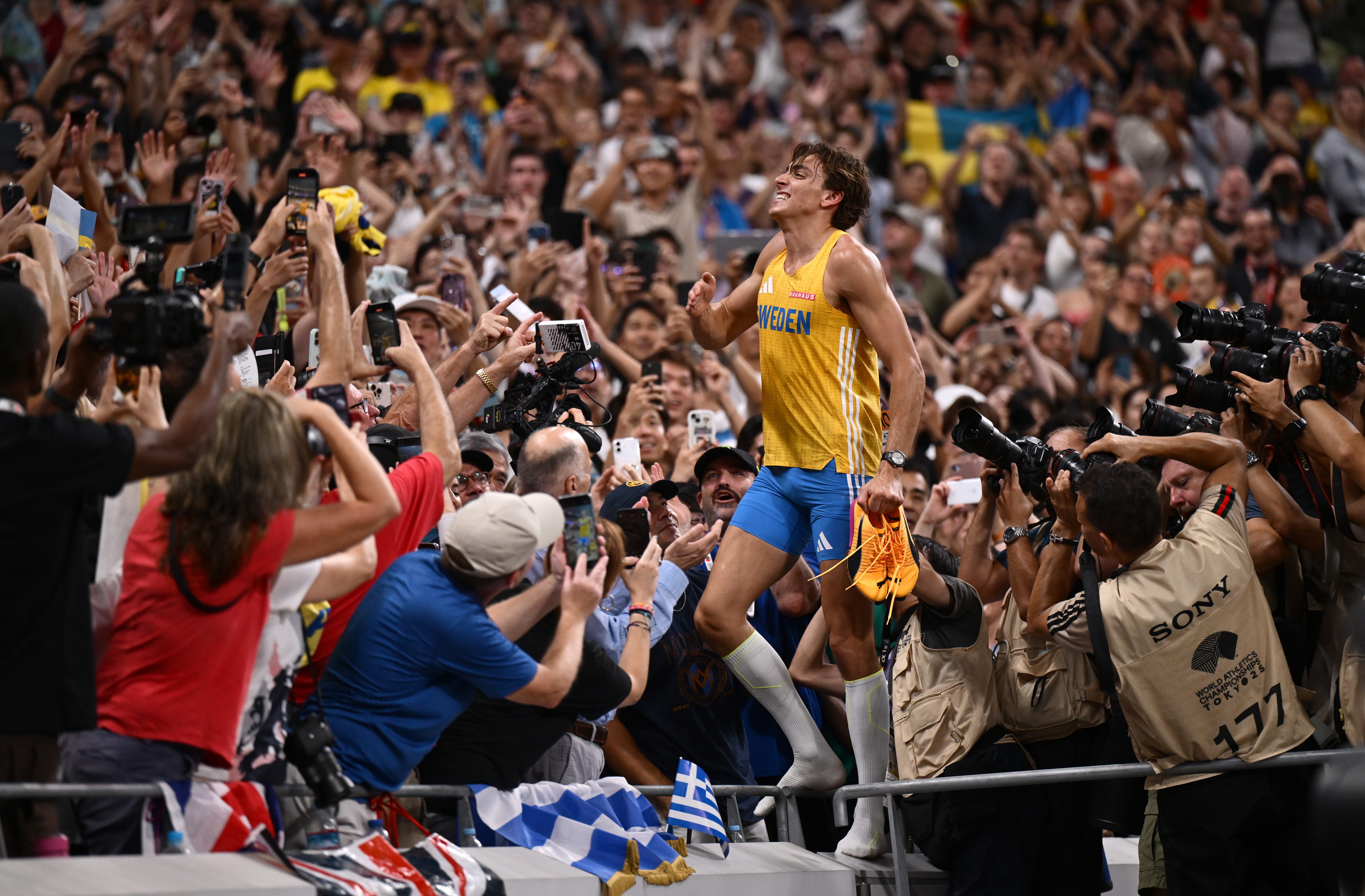 Armand Duplantis celebrates in front of a heaving crowd at the Olympic stadium.