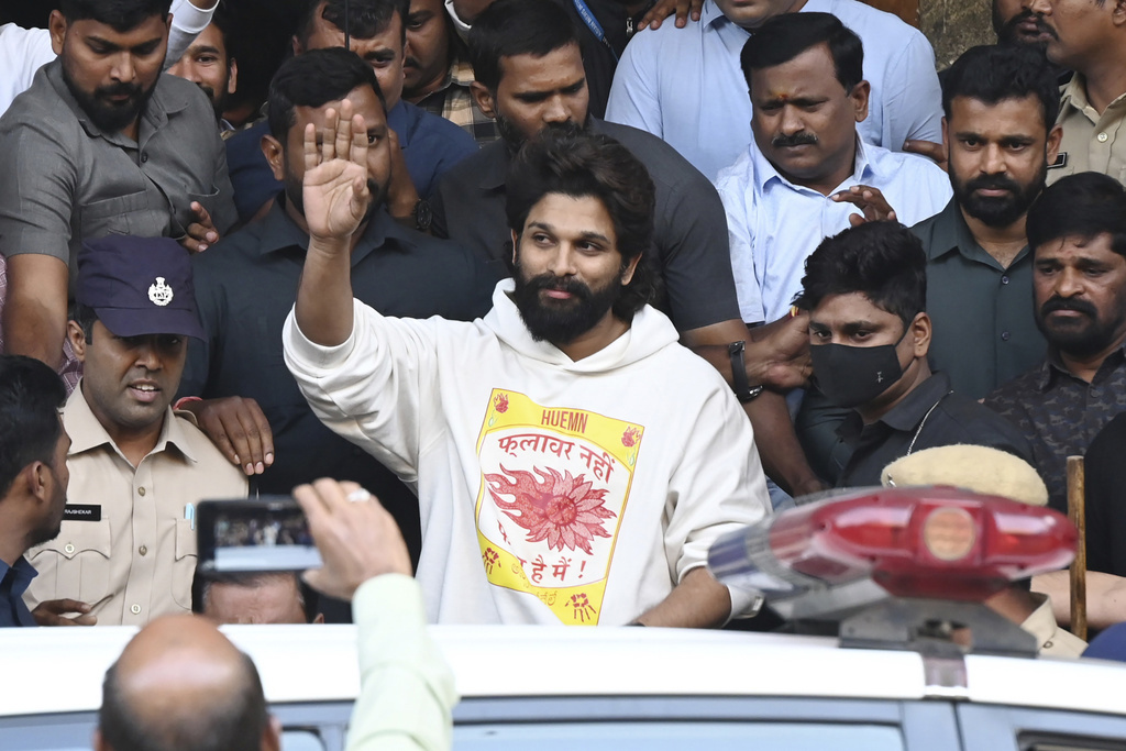 Indian Southern film actor Allu Arjun, center, greets his fans in Hyderabad, India, Friday, Dec. 13, 2024, as he leaves a hospital where he was taken for medical checkup by policemen before arresting him after his appearance at a film screening allegedly led to a crush of fans in which a woman died. (AP Photo)