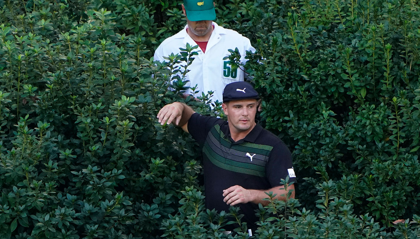 Bryson DeChambeau searches for his ball at the 13th hole.