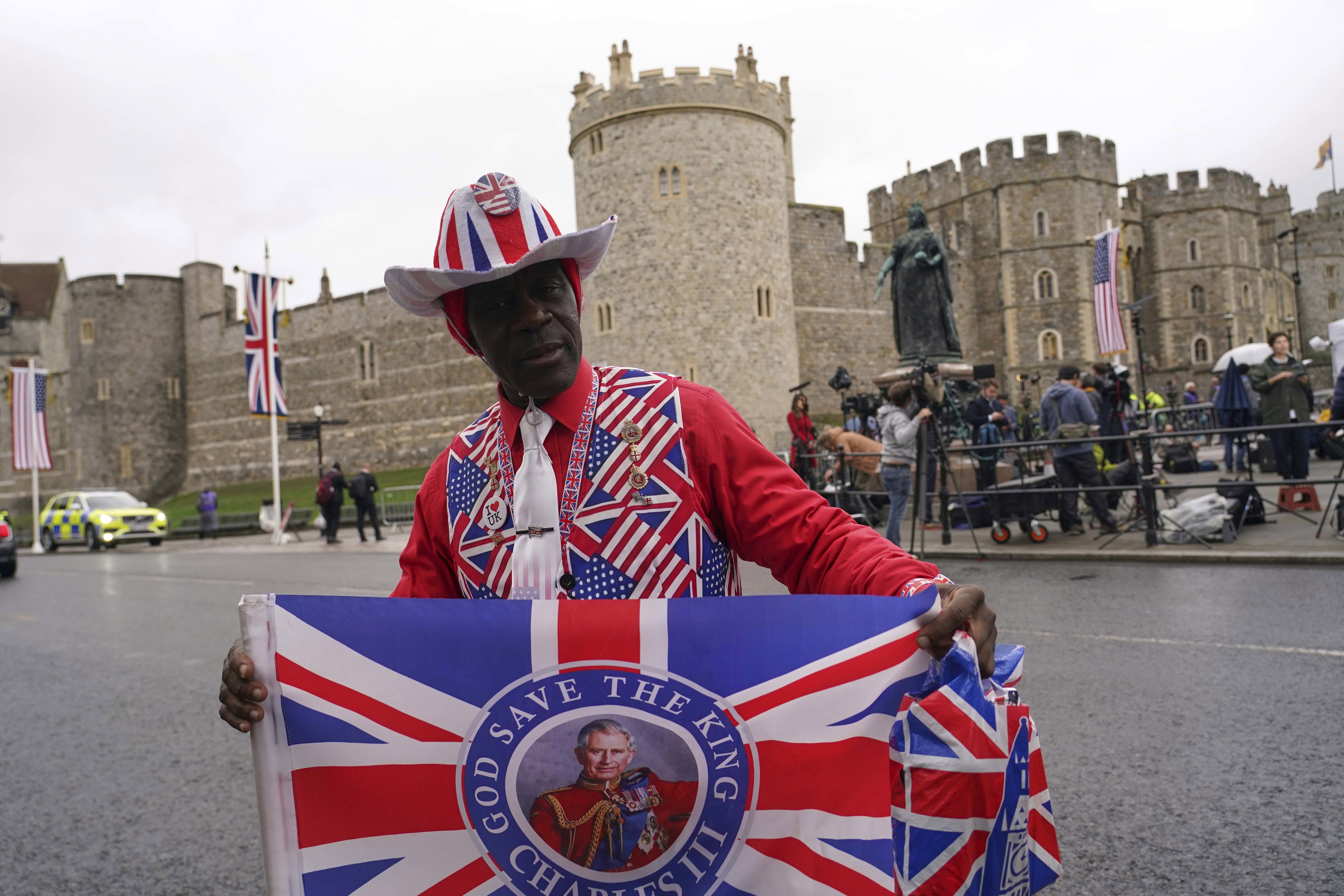 A Royal supporter poses for photos in front of Windsor Castle in Windsor.