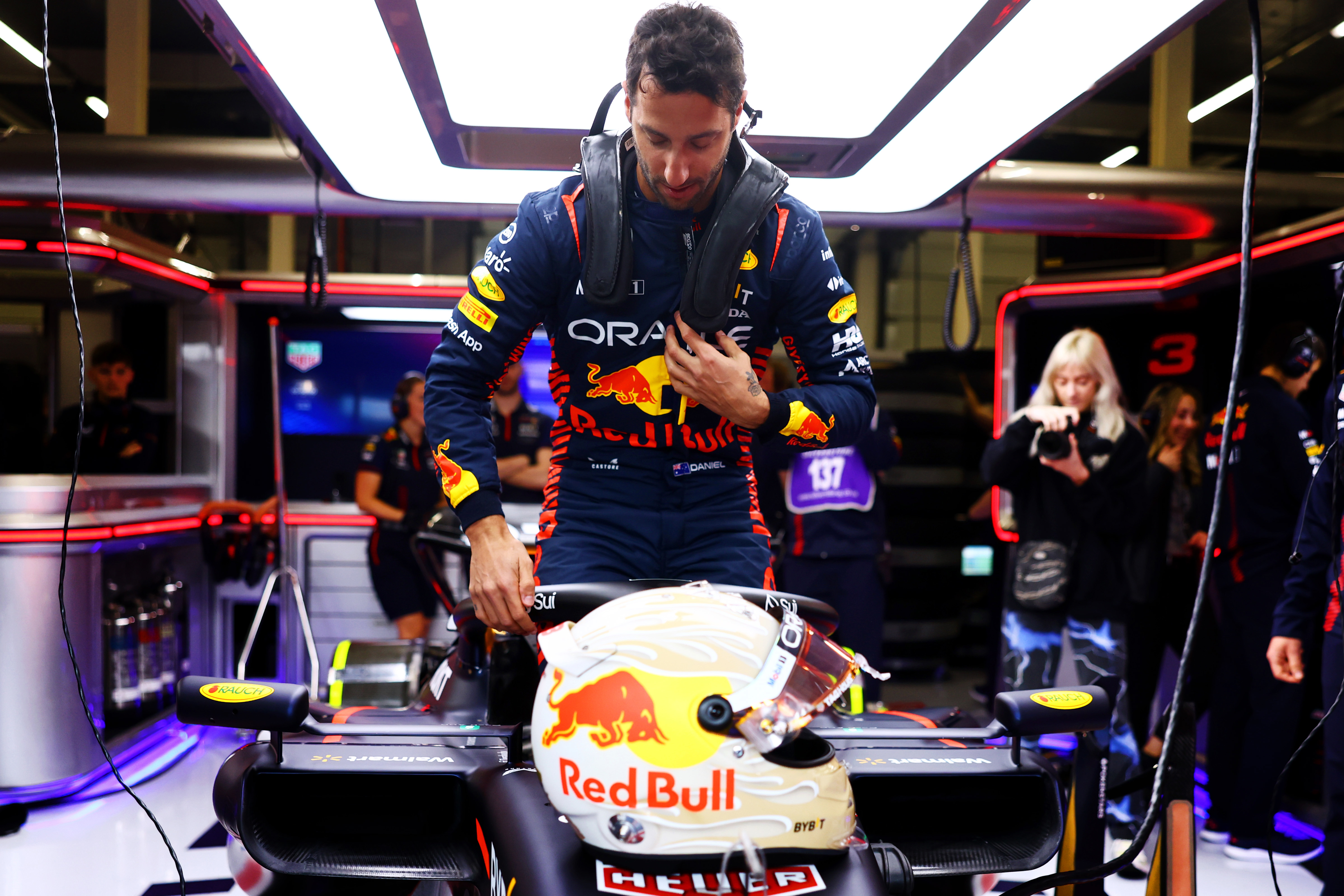 Daniel Ricciardo climbs into the Red Bull RB19 in the garage as he prepares to drive during F1 testing at Silverstone Circuit.