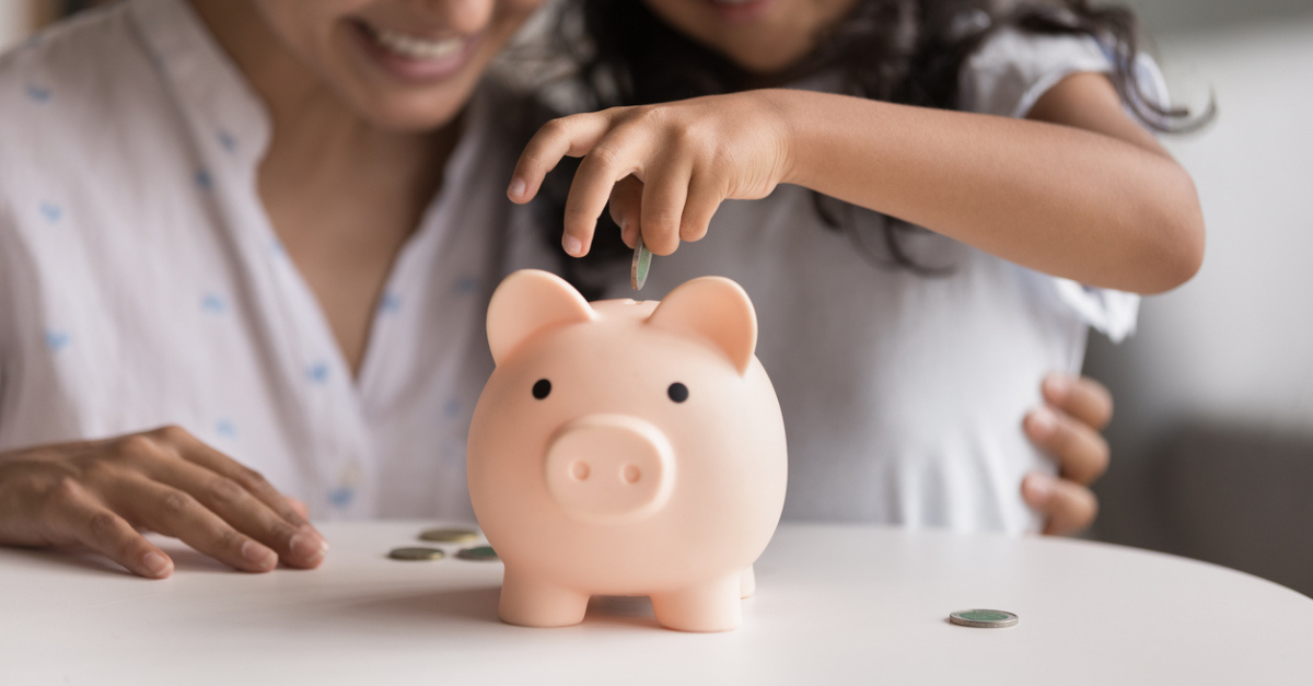 Woman and child sitting behind a piggybank