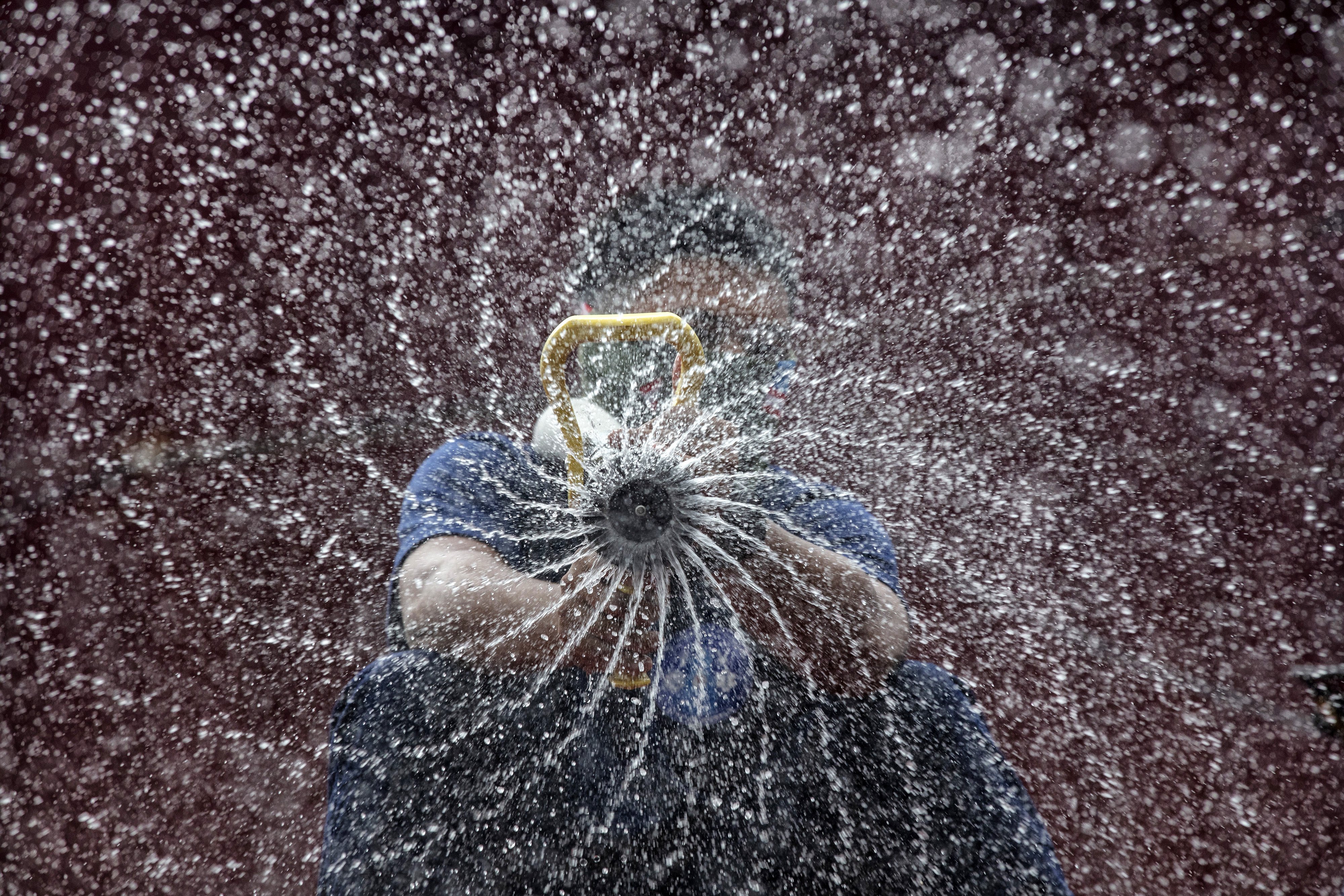 A disinfection worker sprays anti-septic solution against COVID-19 aboard a firetruck along a street on March 11, 2020 in Manila, Philippines. Picture: Ezra Acayan