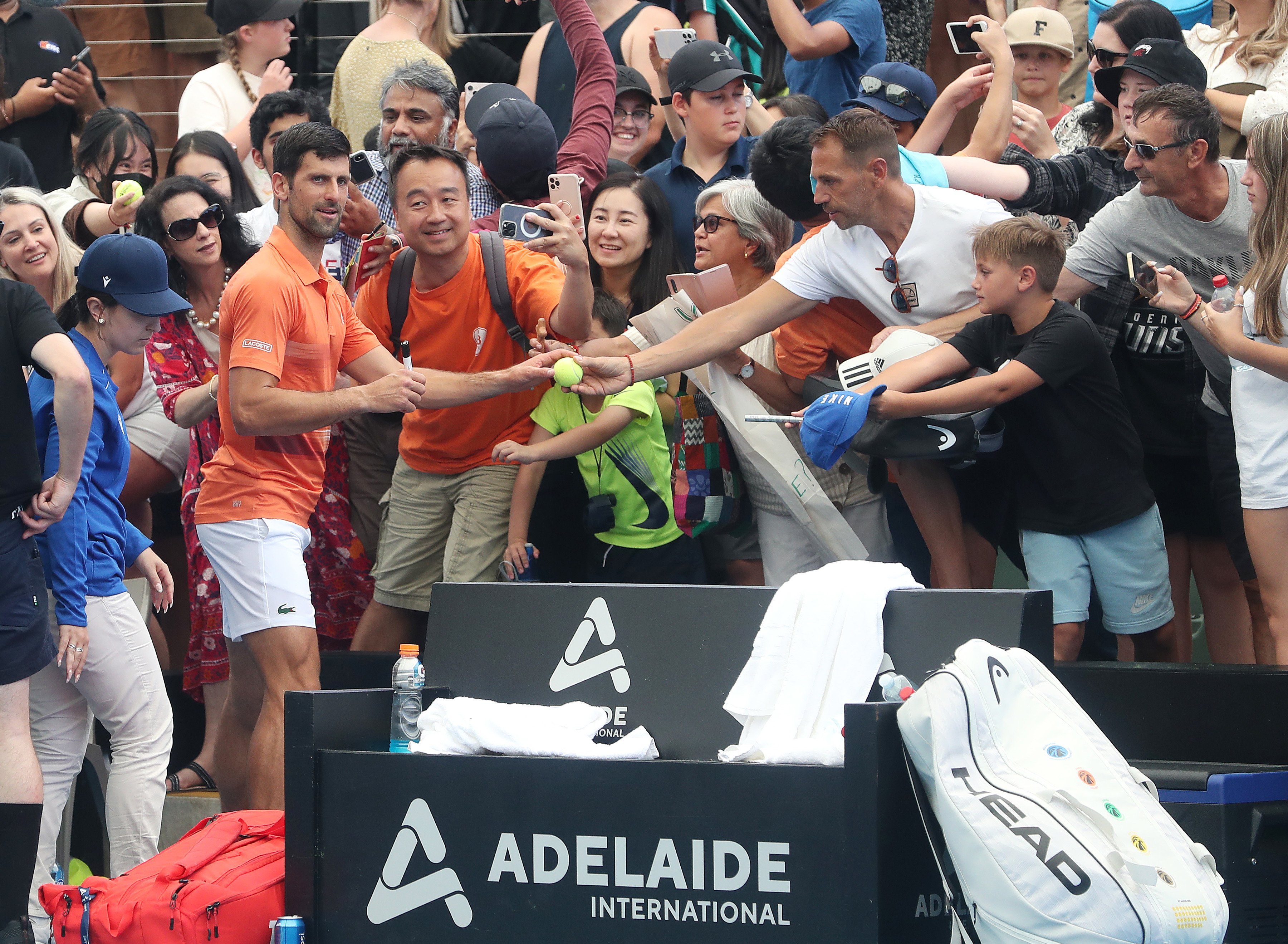 ADELAIDE, AUSTRALIA - JANUARY 02:  Novak Djokovic of Serbia signs autographs after his doubles match with  Vasek Pospisil of Canada  during day two of the 2023 Adelaide International at Memorial Drive on January 02, 2023 in Adelaide, Australia. (Photo by Sarah Reed/Getty Images)