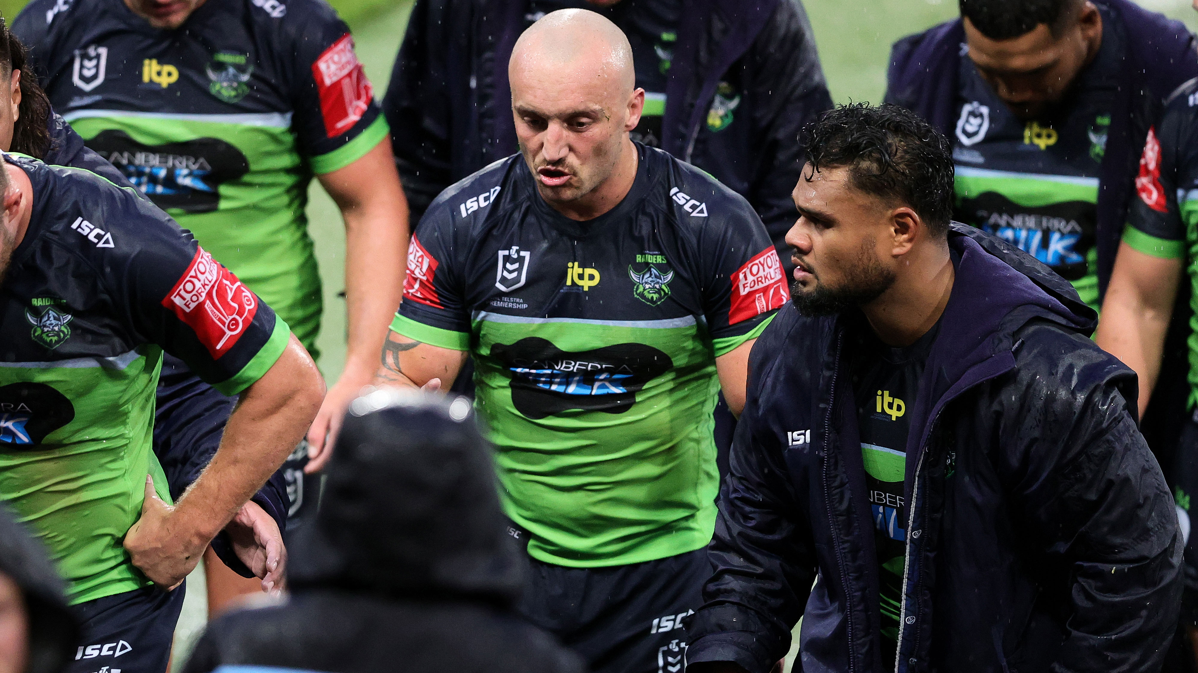 Josh Hodgson walks off the field with Raiders teammates.